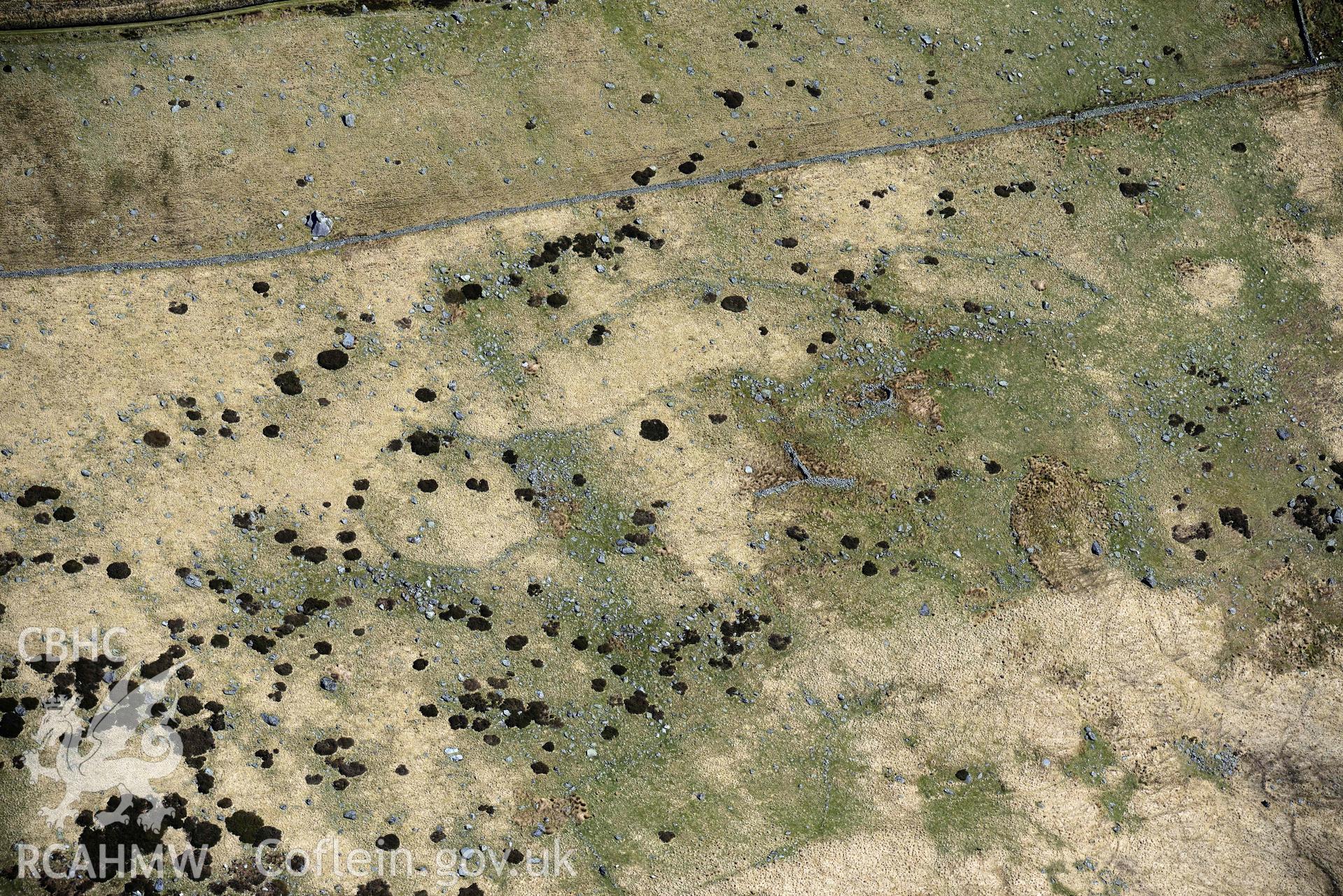 Huts and enclosures, south-east of Glan Llugwy. Oblique aerial photograph taken during the Royal Commission’s programme of archaeological aerial reconnaissance by Toby Driver on 20 April 2018.