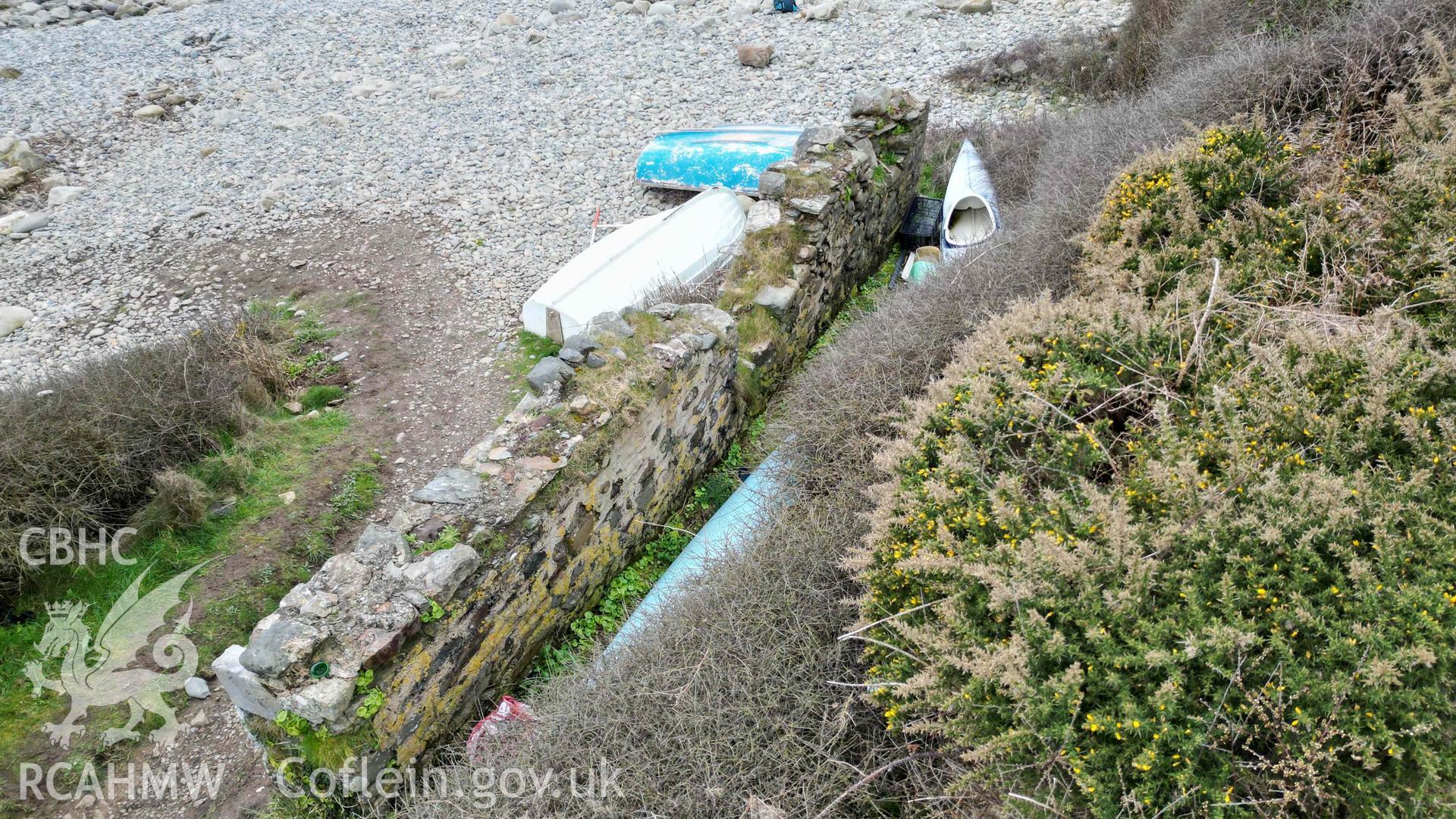 Oblique view of the ruined boathouse at Aber Bach on 02/04/2024, looking west, scales are 1m. Produced by Julian Whitewright of the RCAHMW Survey Team.