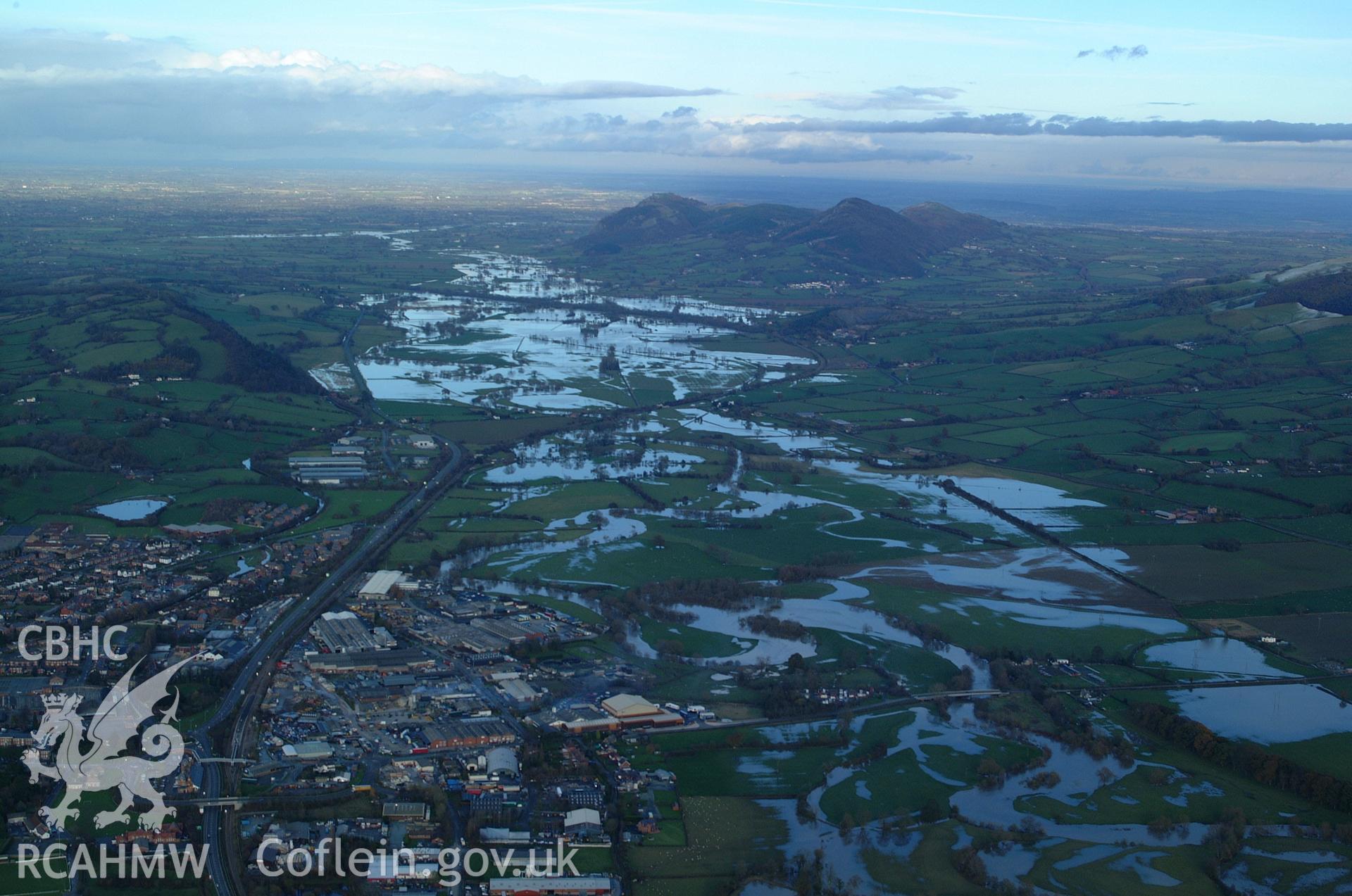 RCAHMW colour oblique aerial photograph of Welshpool. A wide landscape view looking north-east to the Breiddin with the Severn in flood. Taken on 19 November 2004 by Toby Driver