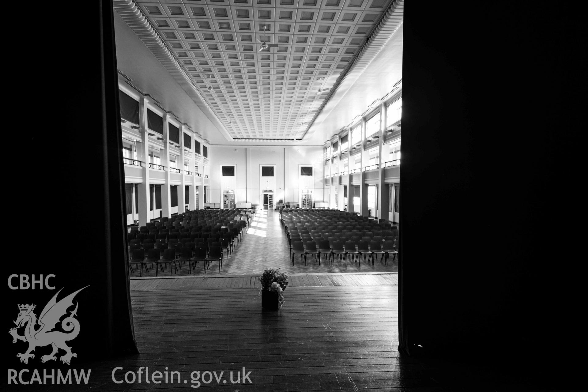 View from behind stage curtains of assembly hall. Black and white. Bishop Gore School, Swansea