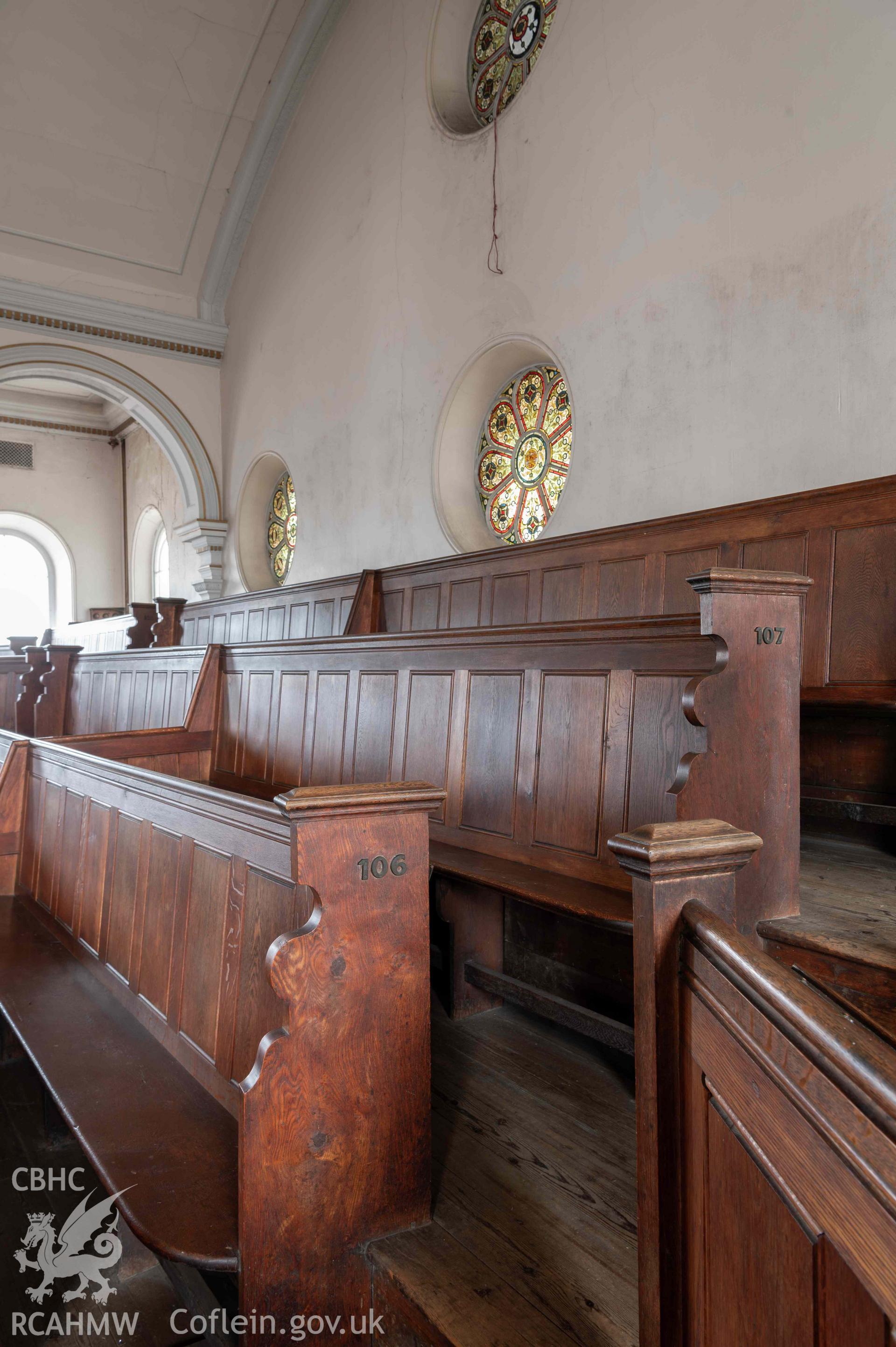 Capel Zion Baptist Chapel, Newtown - auditorium, detail of pew ends to central bank of pews in end gallery.