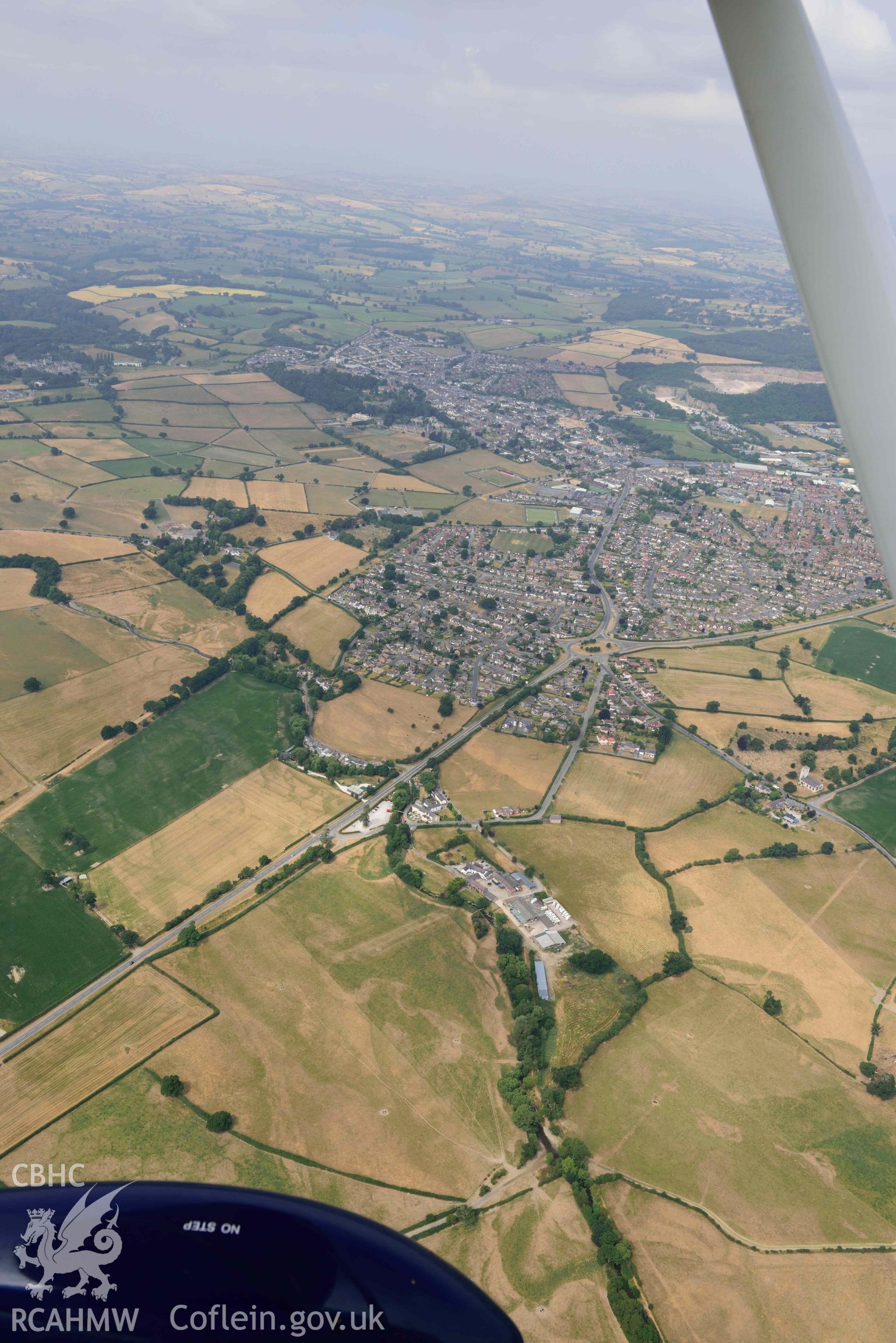 Denbigh Town with cropmarks from the south east. Oblique aerial photograph taken during the Royal Commission’s programme of archaeological aerial reconnaissance by Toby Driver on 10 July 2018.