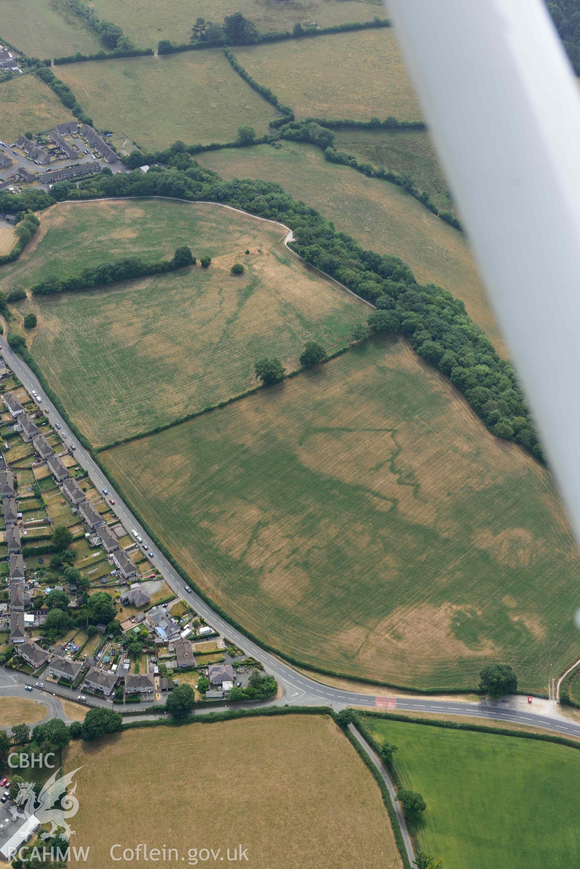 Lon Llewelyn cropmarks. Oblique aerial photograph taken during the Royal Commission’s programme of archaeological aerial reconnaissance by Toby Driver on 10 July 2018.