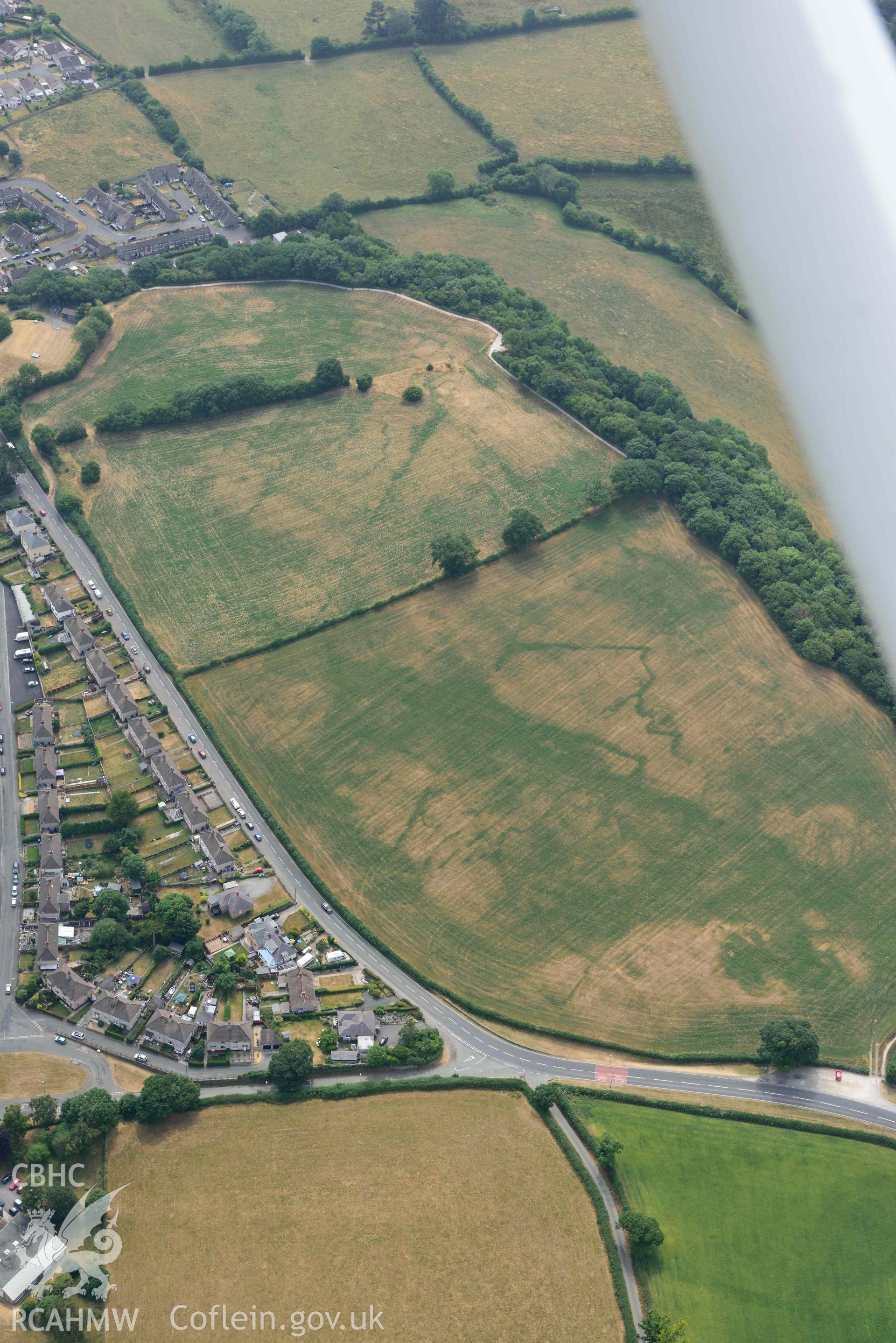 Lon Llewelyn cropmarks. Oblique aerial photograph taken during the Royal Commission’s programme of archaeological aerial reconnaissance by Toby Driver on 10 July 2018.