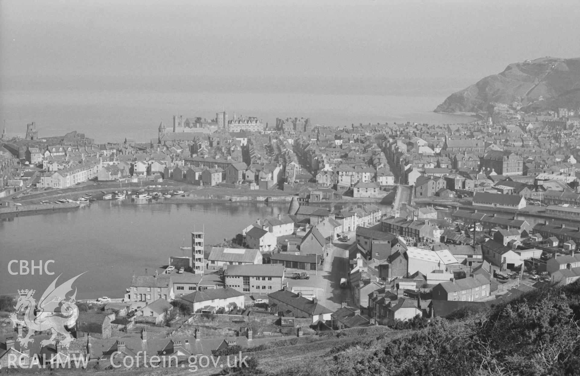 Digital copy of a black and white negative showing view of Aberystwyth harbour and town, and Trefechan, from the north end of Pendinas. Firestation in centre of image. Photographed by Arthur Chater on 3 April 1969. Looking north from Grid Reference SN 5830 8078.