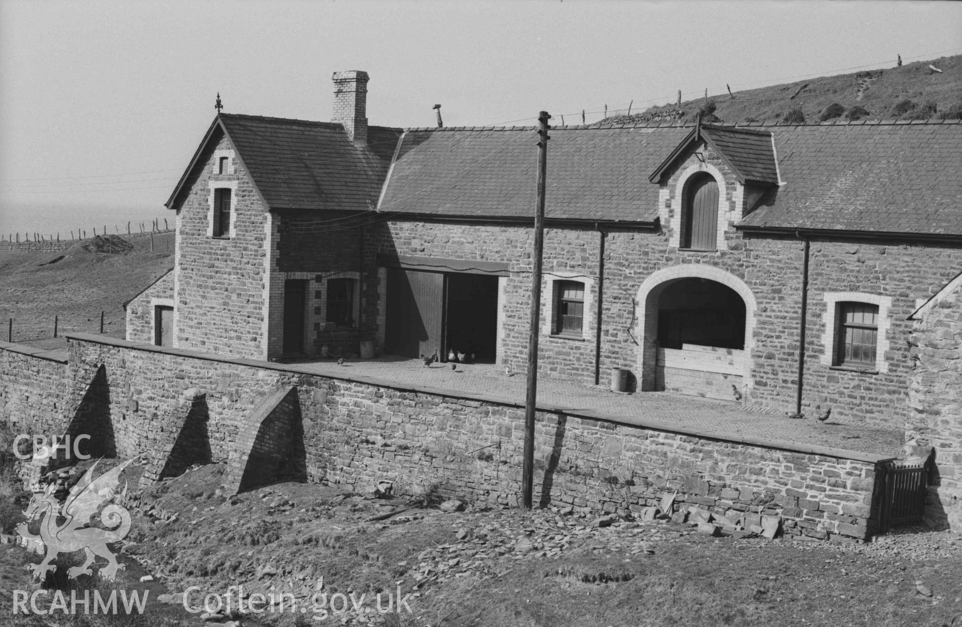 Digital copy of a black and white negative showing Wallog farm buildings on the north side of the stream; stone on west gable inscribed "erected 1891 by John Francis". Photographed by Arthur Chater on 4 April 1969. Looking north west from Grid Reference SN 5917 8568.
