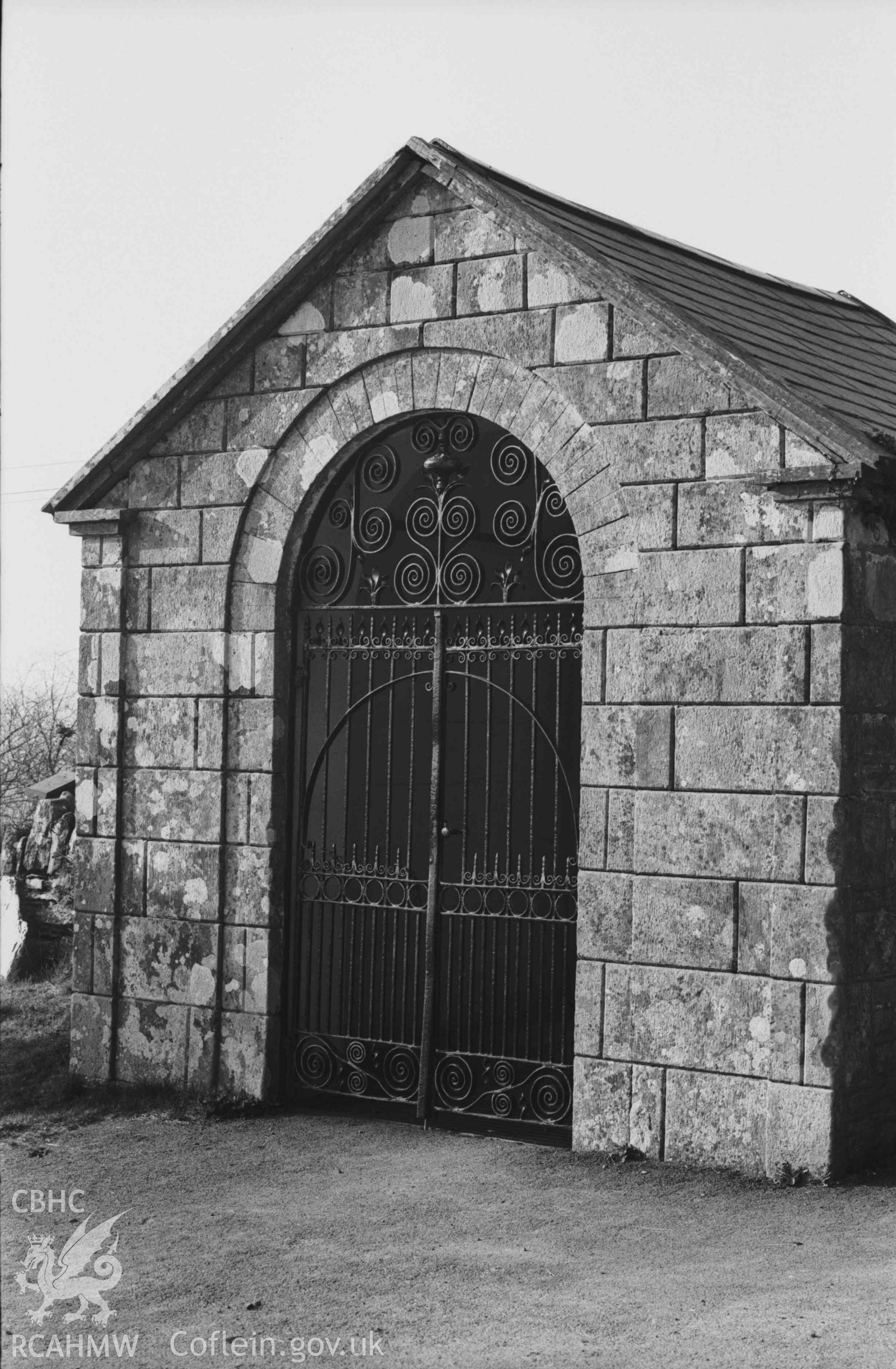 Digital copy of a black and white negative showing Troedyraur churchyard gates from the road. Photographed by Arthur Chater on 5 April 1969. Looking north west from Grid Reference SN 3271 4534.