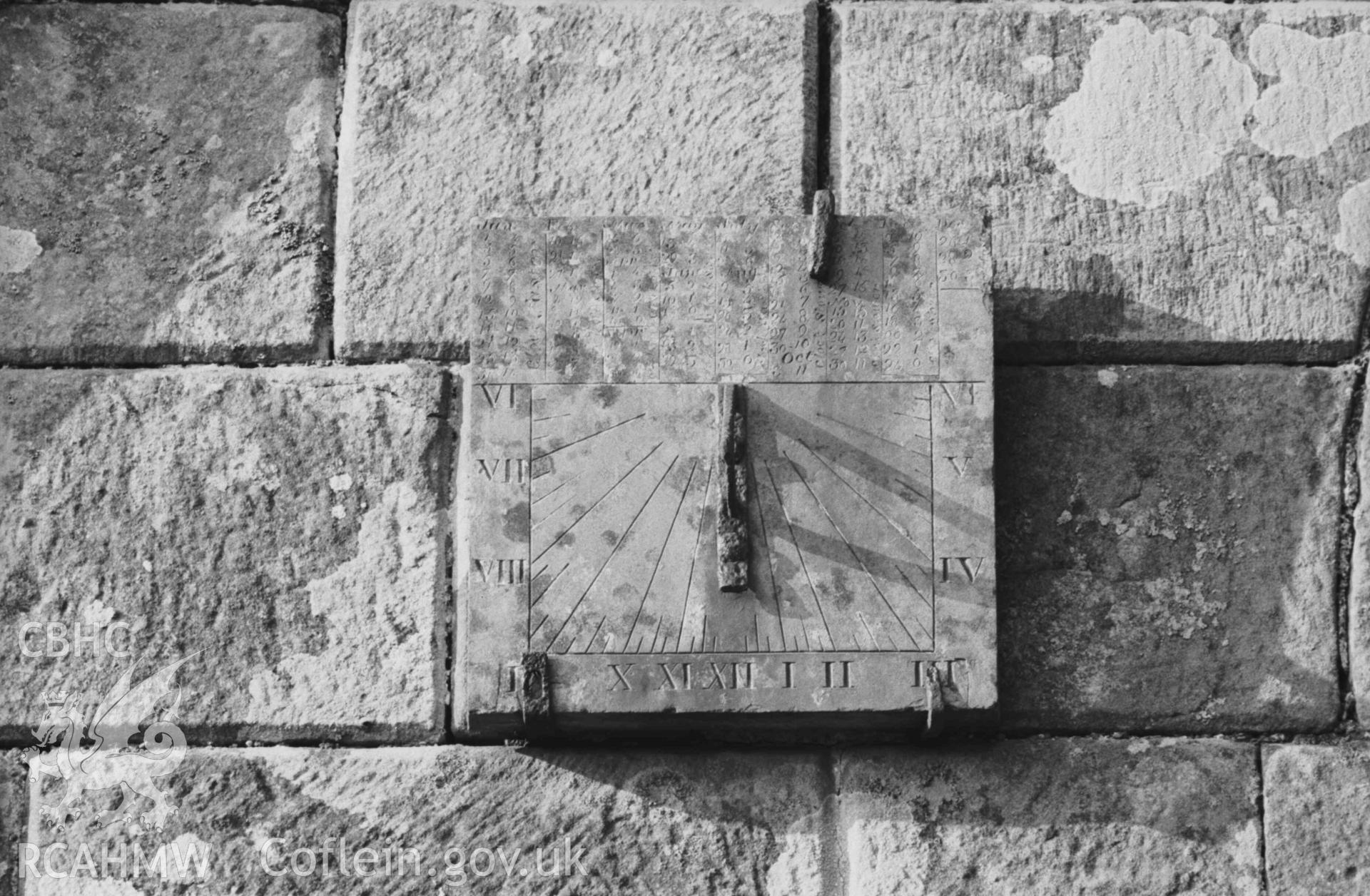 Digital copy of a black and white negative showing carved stone sundial on the south wall of the south porch of Troedyraur church. Photographed by Arthur Chater on 5 April 1969. Looking north from Grid Reference SN 3270 4535.