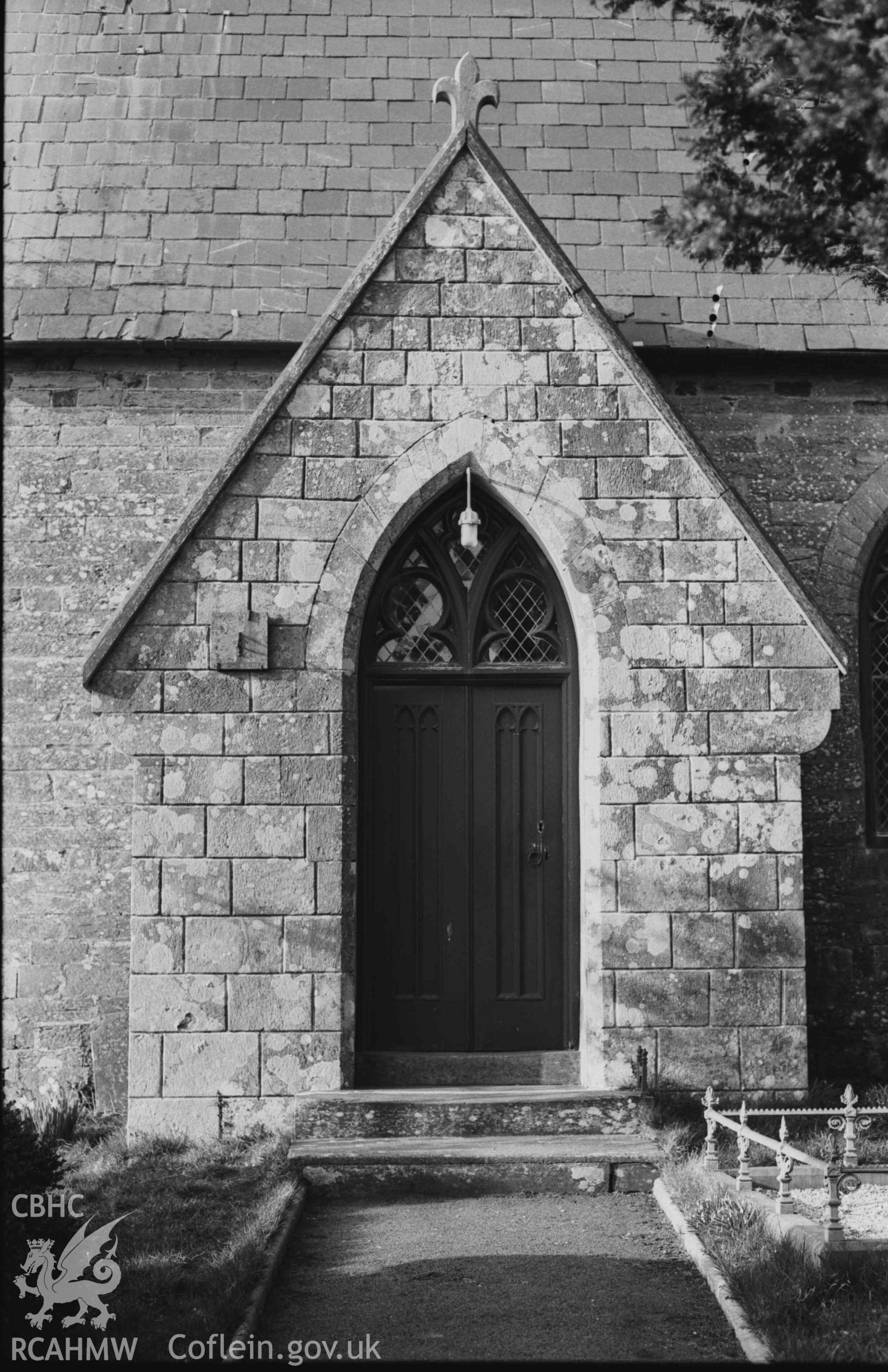 Digital copy of a black and white negative showing doors to Troedyraur church, with sundial on the left. Photographed by Arthur Chater on 5 April 1969. Looking north from Grid Reference SN 3270 4535.