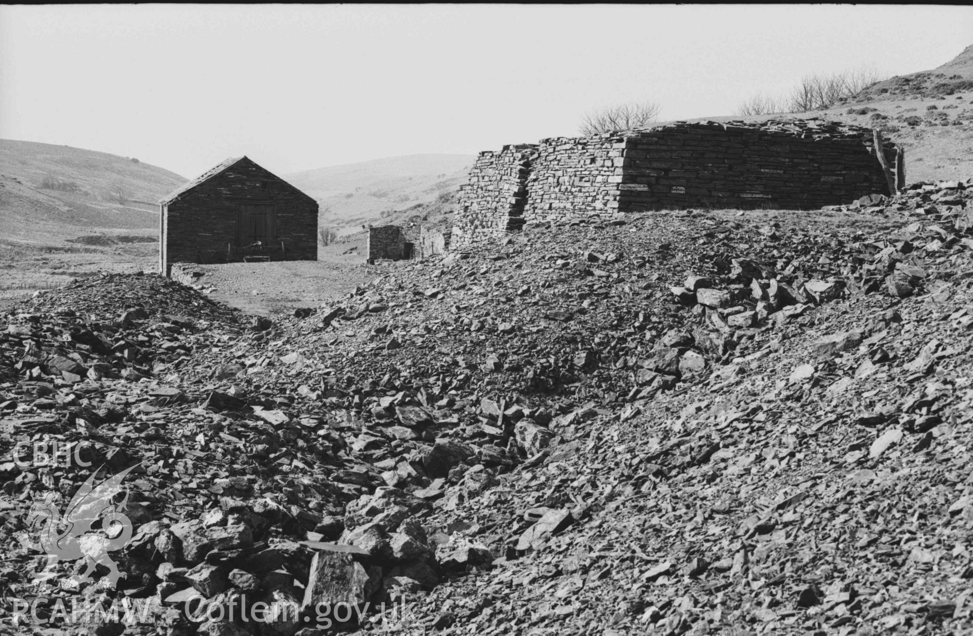 Digital copy of a black and white negative showing Llawr-y-Cwm-bach lead mine. Photographed by Arthur Chater on 6 April 1969. Looking west from Grid Reference SN 7077 8538.