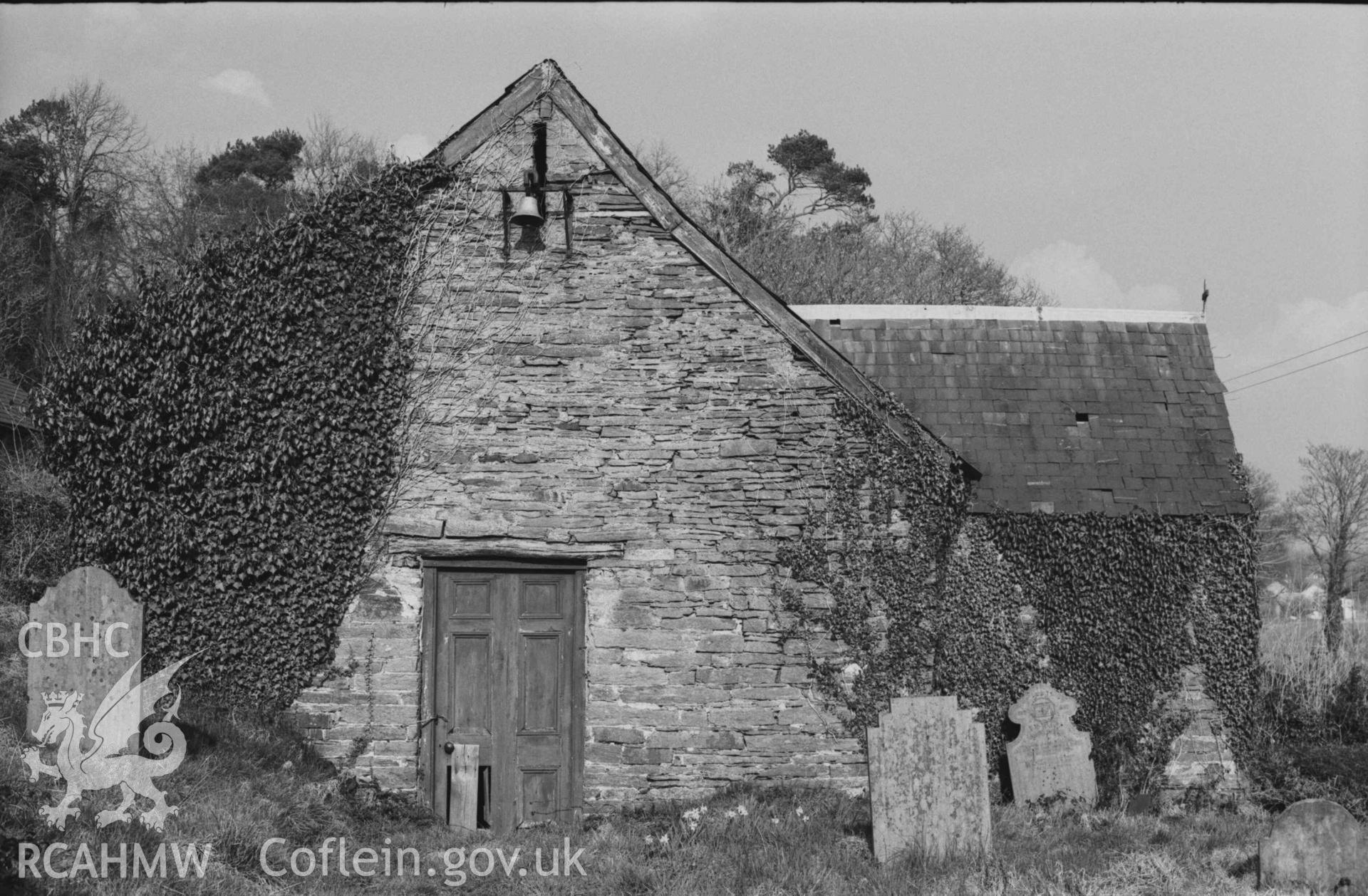 Digital copy of a black and white negative showing the west end and bell of the deserted Holy Cross Church. Photographed by Arthur Chater on 7 April 1969. Looking east from Grid Reference SN 2185 4372.