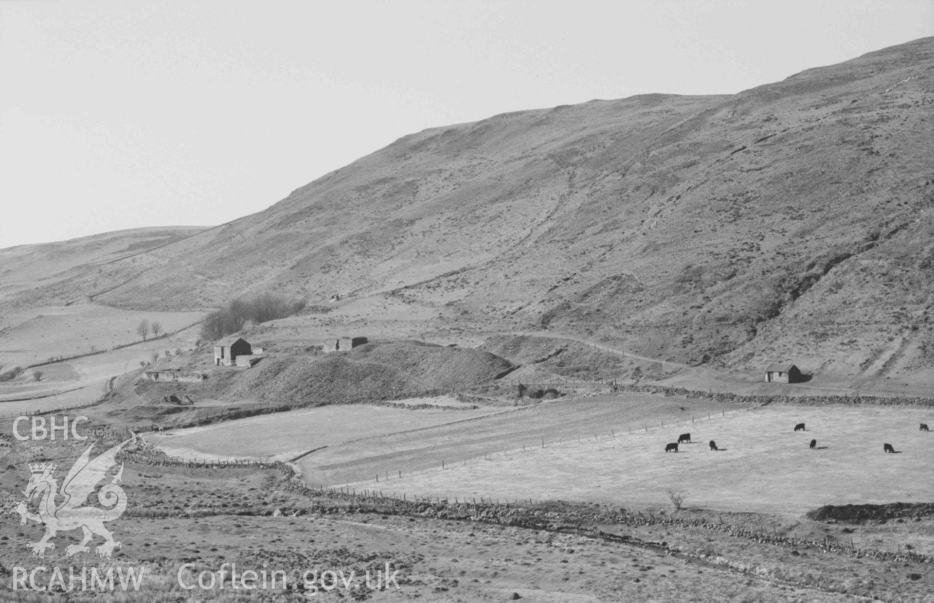 Digital copy of a black and white negative showing Llawr-y-cwm-bach mine; Esgair Goch behind. Photographed by Arthur Chater on 6 April 1969. Looking north west from Grid Reference SN 7095 8512.