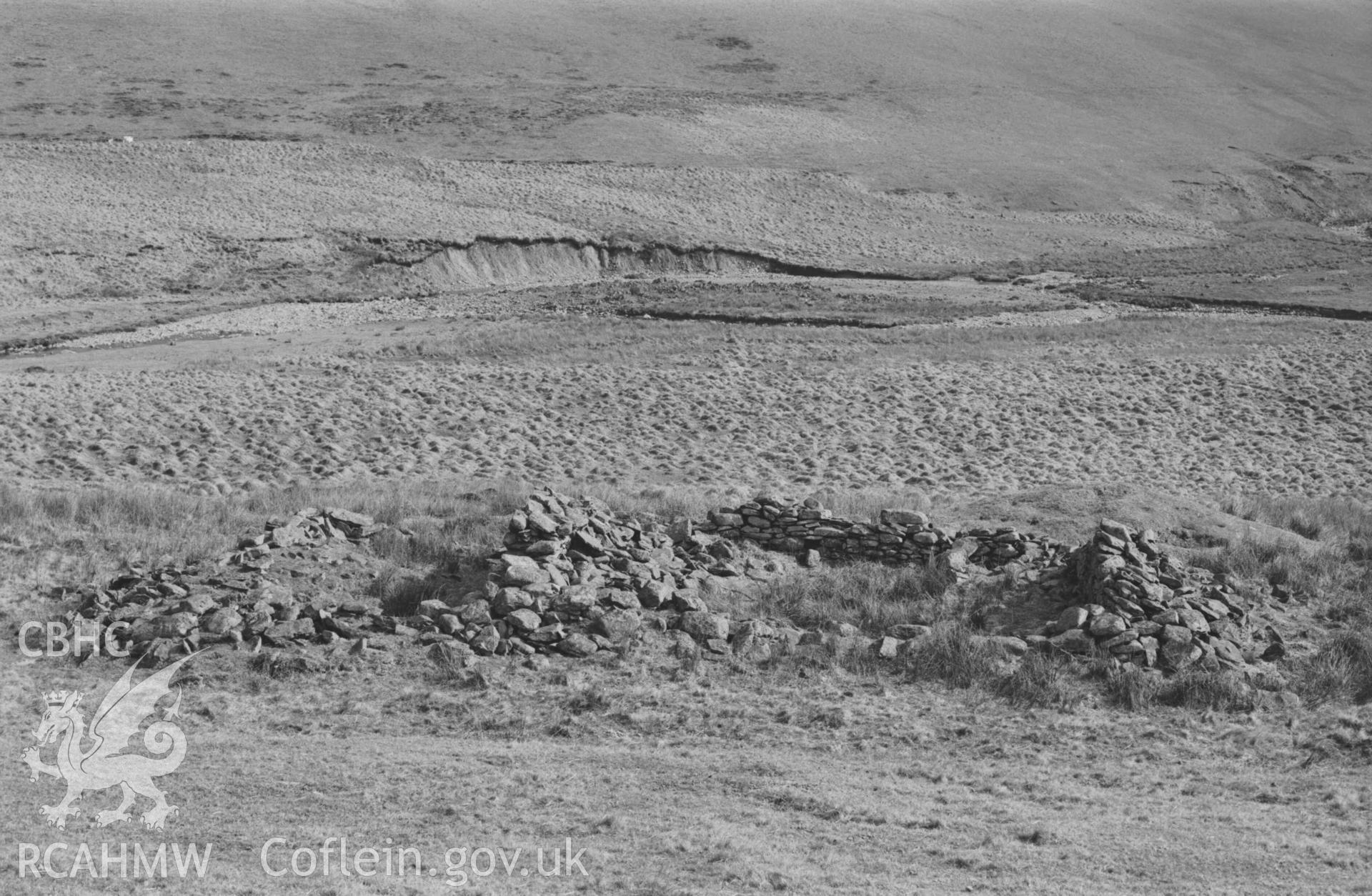 Digital copy of a black and white negative showing ruin of Hengae; Afon Claerwen beyond. Walls are c. 35cm thick, built from mostly river-worn stones. Photographed by Arthur Chater on 8 April 1969. Looking south east from Grid Reference SN 8202 6809.