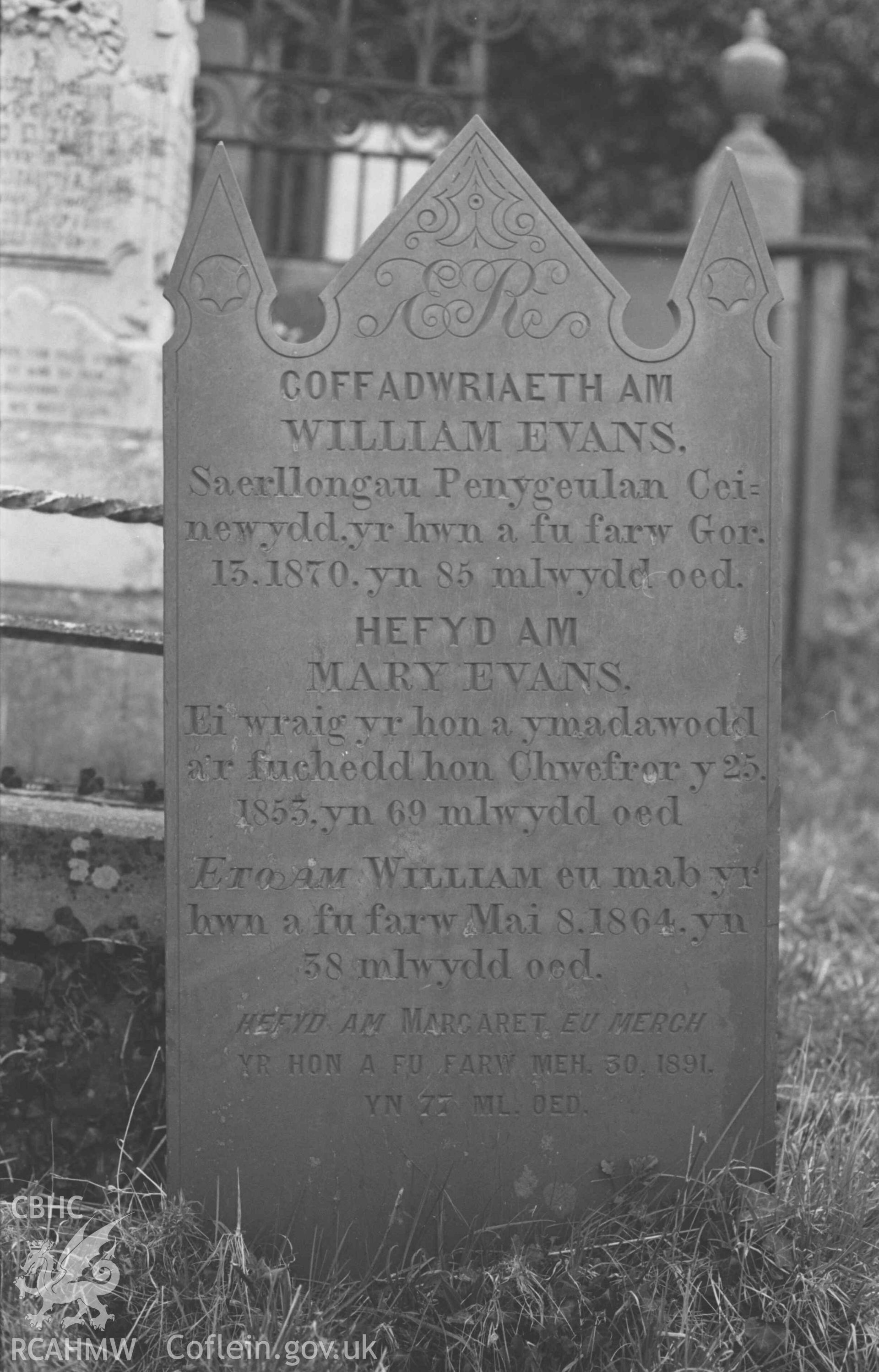 Digital copy of a black and white negative showing the Evans family of Penygeulan's gravestone at St Llwchaeran's Church yard, New Quay (near the north west end). Photographed by Arthur Chater on 9 April 1969. Grid Reference SN 3845 5992.