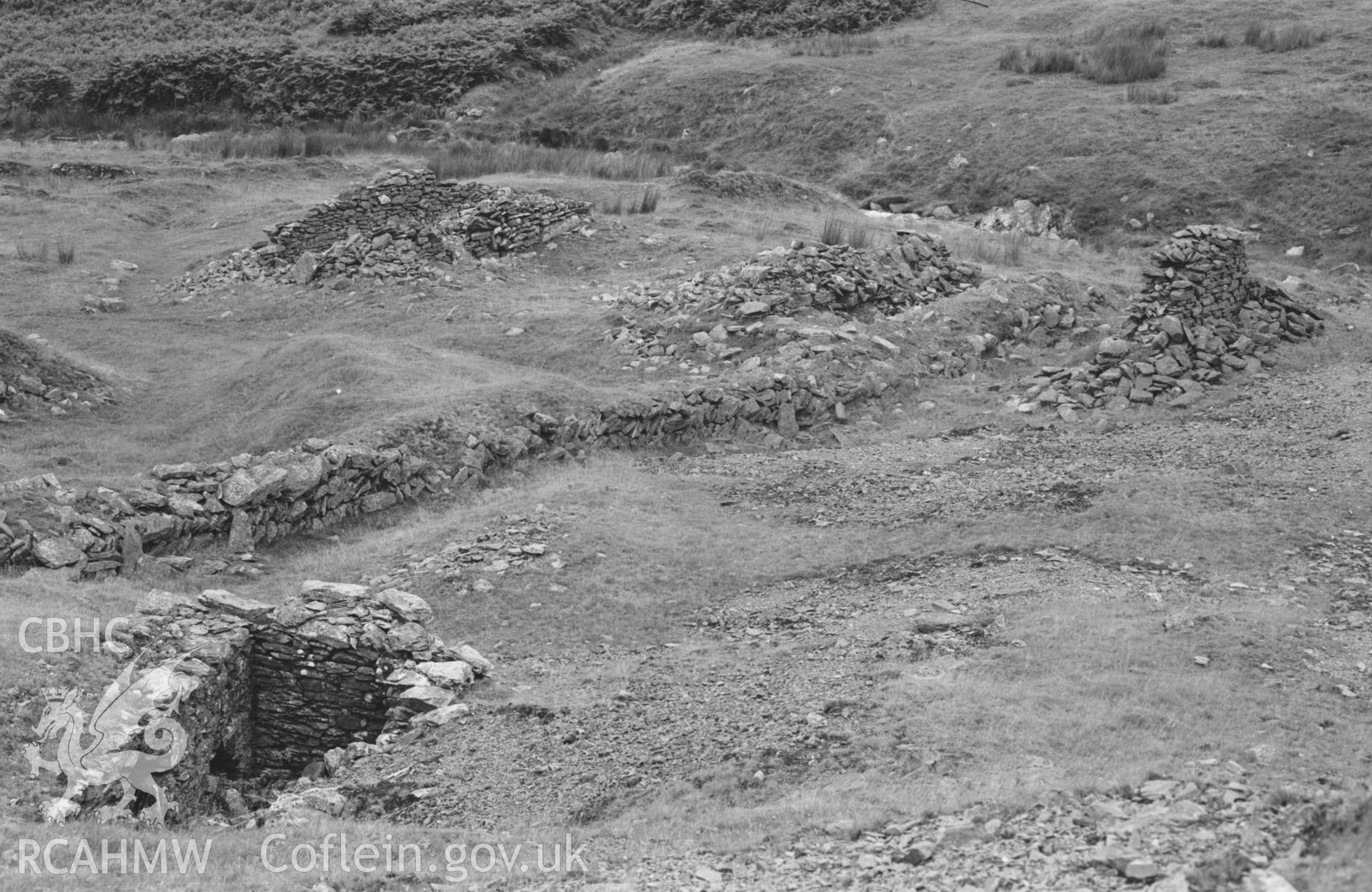 Digital copy of a black and white negative showing lower part of ruins of Rhysgog lead mine, showing wheel pit on the left. Photographed by Arthur Chater on 23 August 1969. Looking north from Grid Reference SN 6807 5380.
