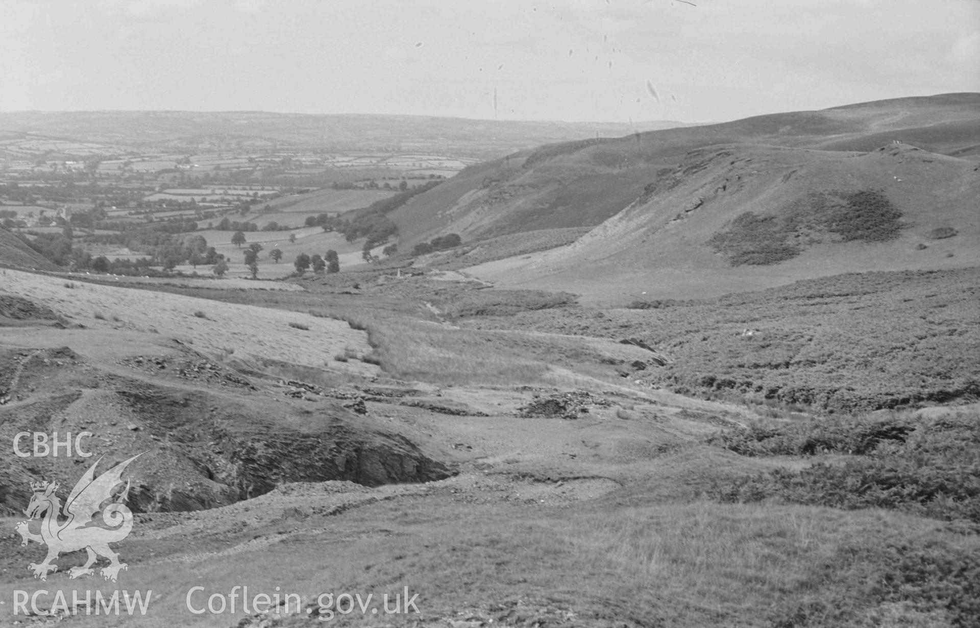 Digital copy of a black and white negative showing view down the Nant Rhysgog from just above the lead mine, showing beech tree, old track, mine ruins, and Talcen y Cnwch hill on the right (Panorama, photograph 2 of 3). Photographed by Arthur Chater on 23 August 1969. Looking north west from Grid Reference SN 6815 5373.