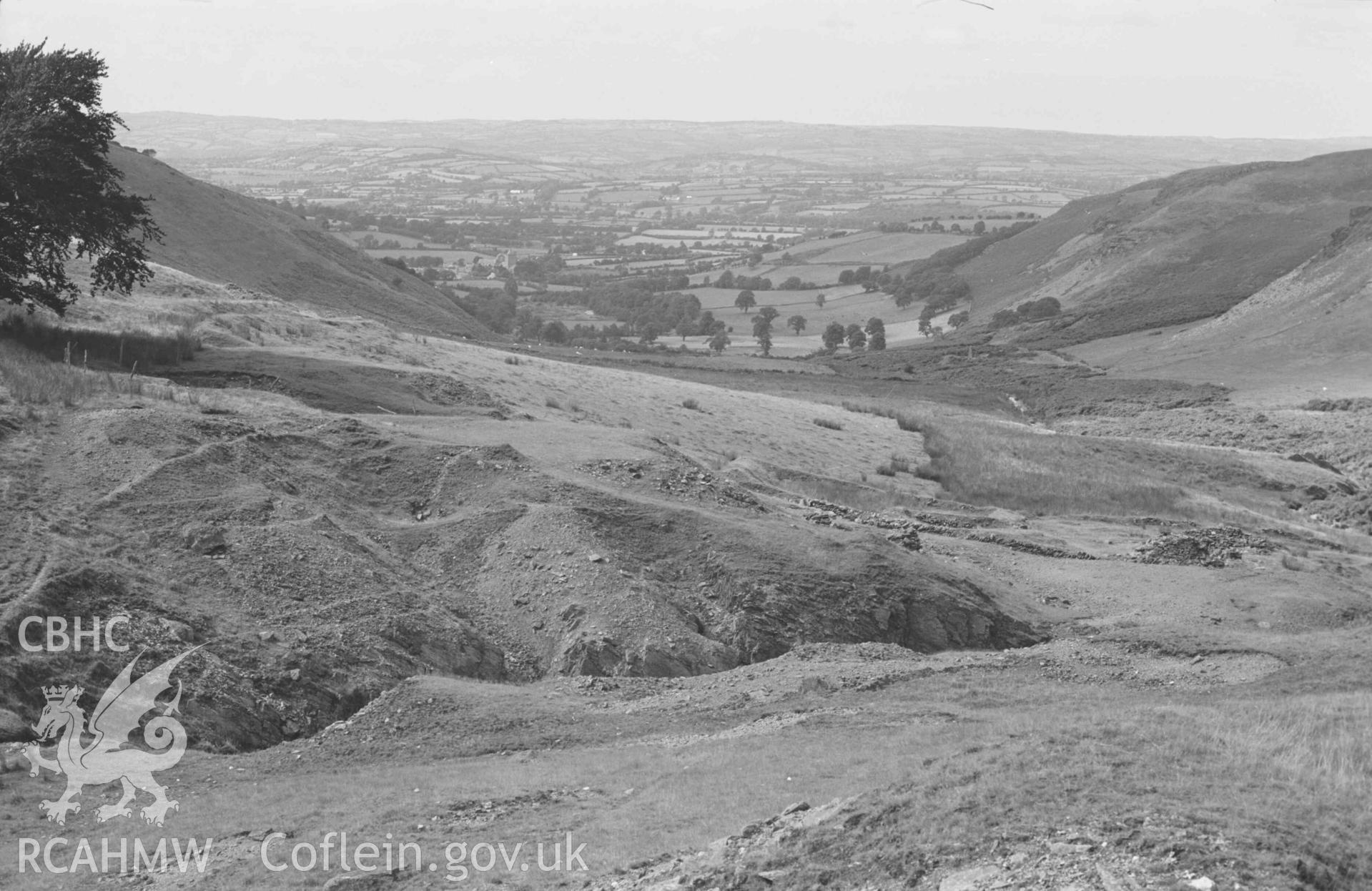 Digital copy of a black and white negative showing view down the Nant Rhysgog, over the lead mine. Photographed by Arthur Chater on 23 August 1969. Looking north west from Grid Reference SN 6815 5373.