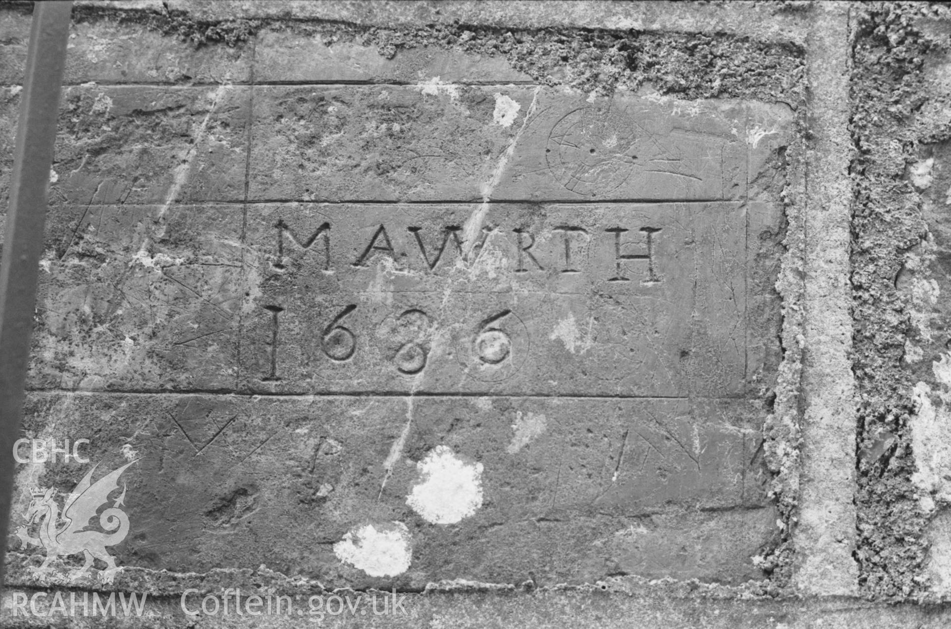 Digital copy of a black and white negative showing inscribed stone, said to have come from the old church at Llangwyrfon, built into the gatepost of the new church. Photographed by Arthur Chater on 27 August 1969, looking north east from Grid Reference SN 5965 7052.