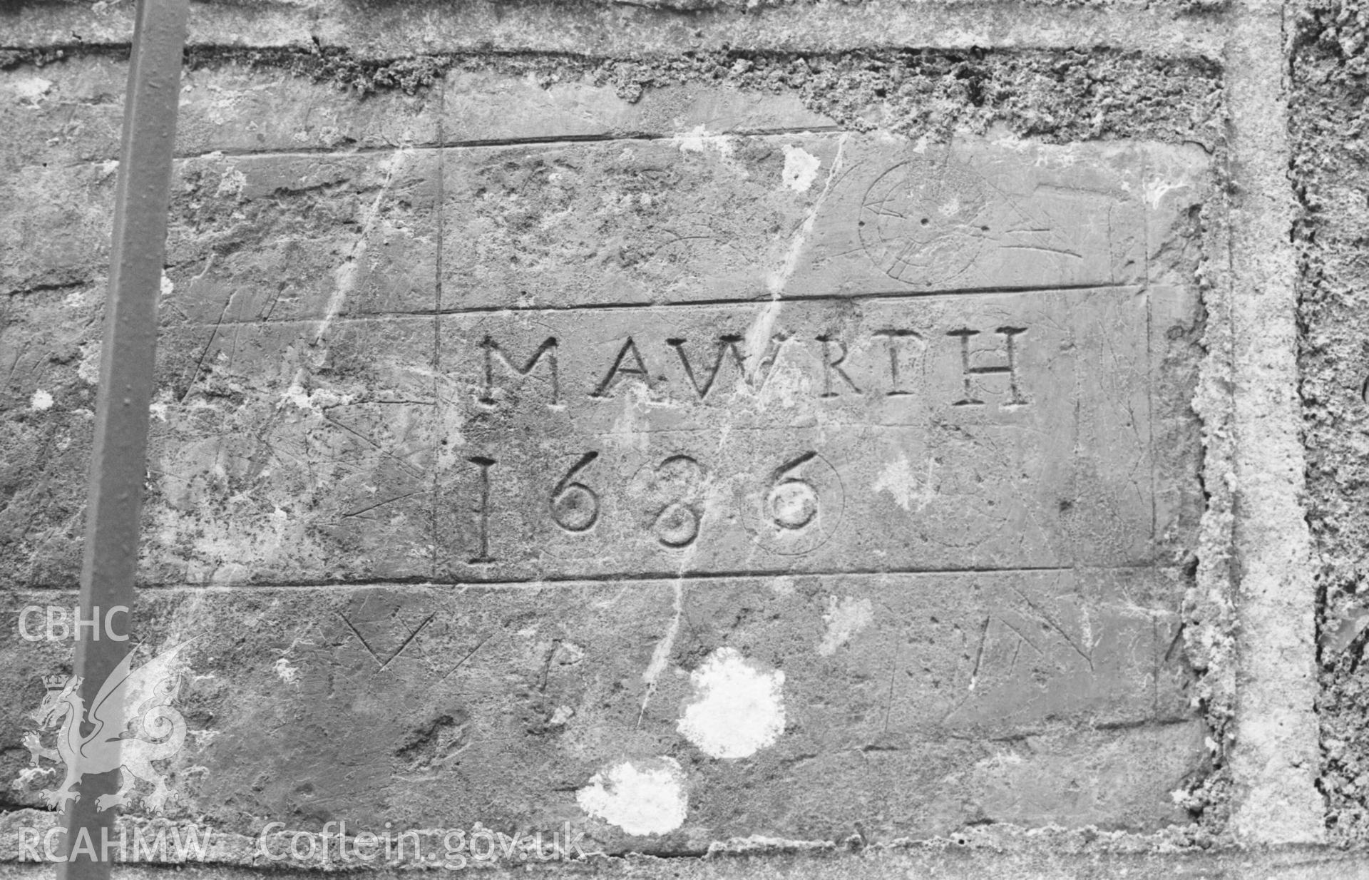 Digital copy of a black and white negative showing inscribed stone, said to have come from the old church at Llangwyrfon, built into the gatepost of the new church. Photographed by Arthur Chater on 27 August 1969, looking north east from Grid Reference SN 5965 7052.