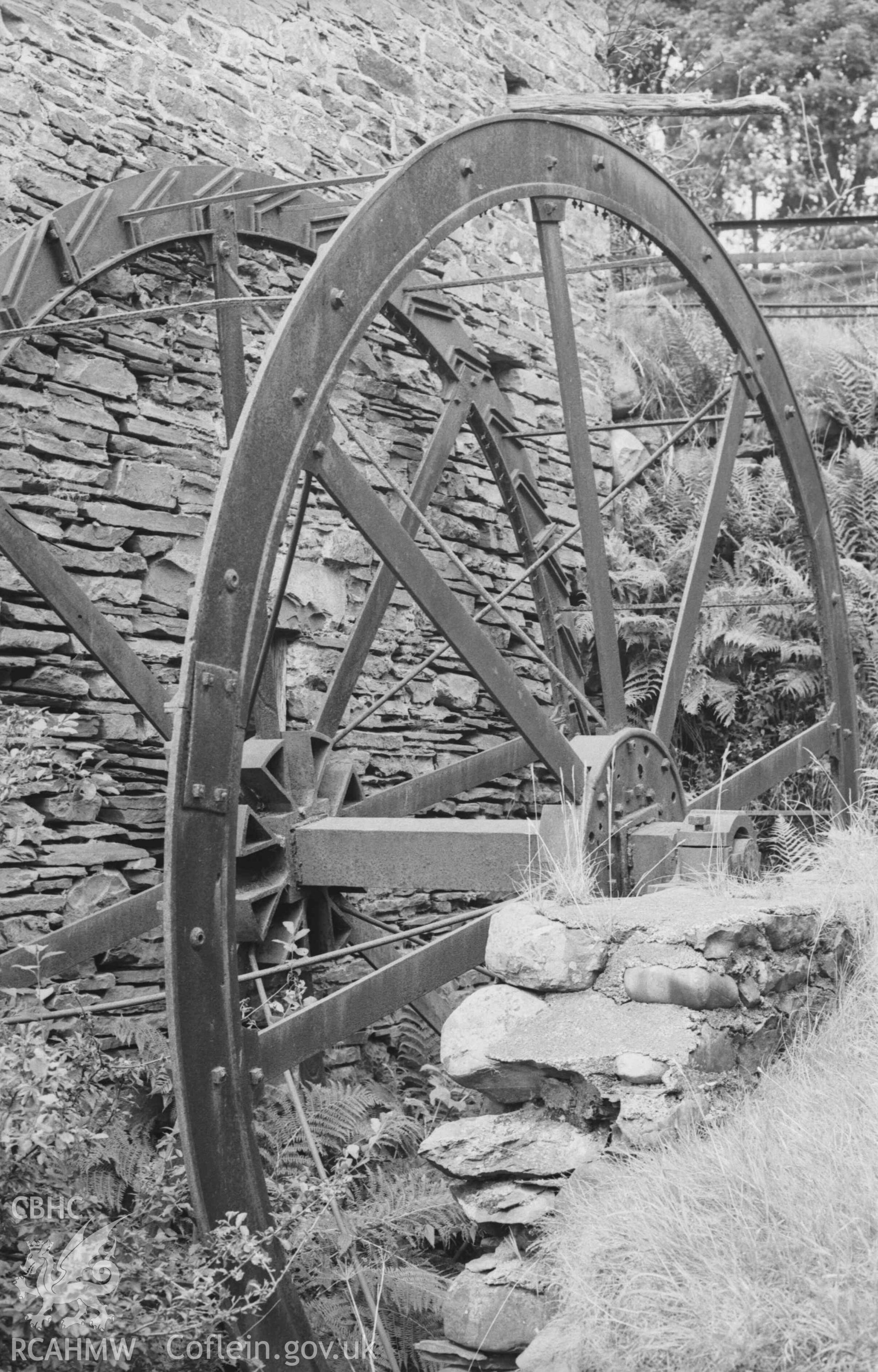 Digital copy of a black and white negative showing iron overshot wheel of Melin y Bont-Goch. Photographed by Arthur Chater on 27 August 1969, looking north from Grid Reference SN 6833 8629.