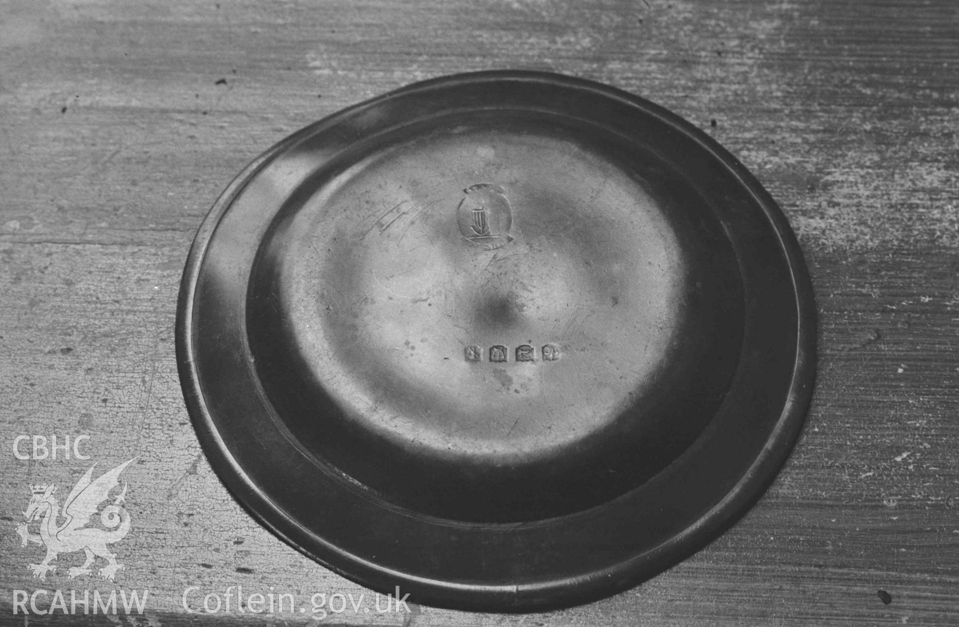 Digital copy of a black and white negative showing pewter plate in the new Capel Gwndwn, 1.5km west of Pentregat; possibly moved from the old chapel. Photographed by Arthur Chater on 28 August 1969, from Grid Reference SN 3401 5214.
