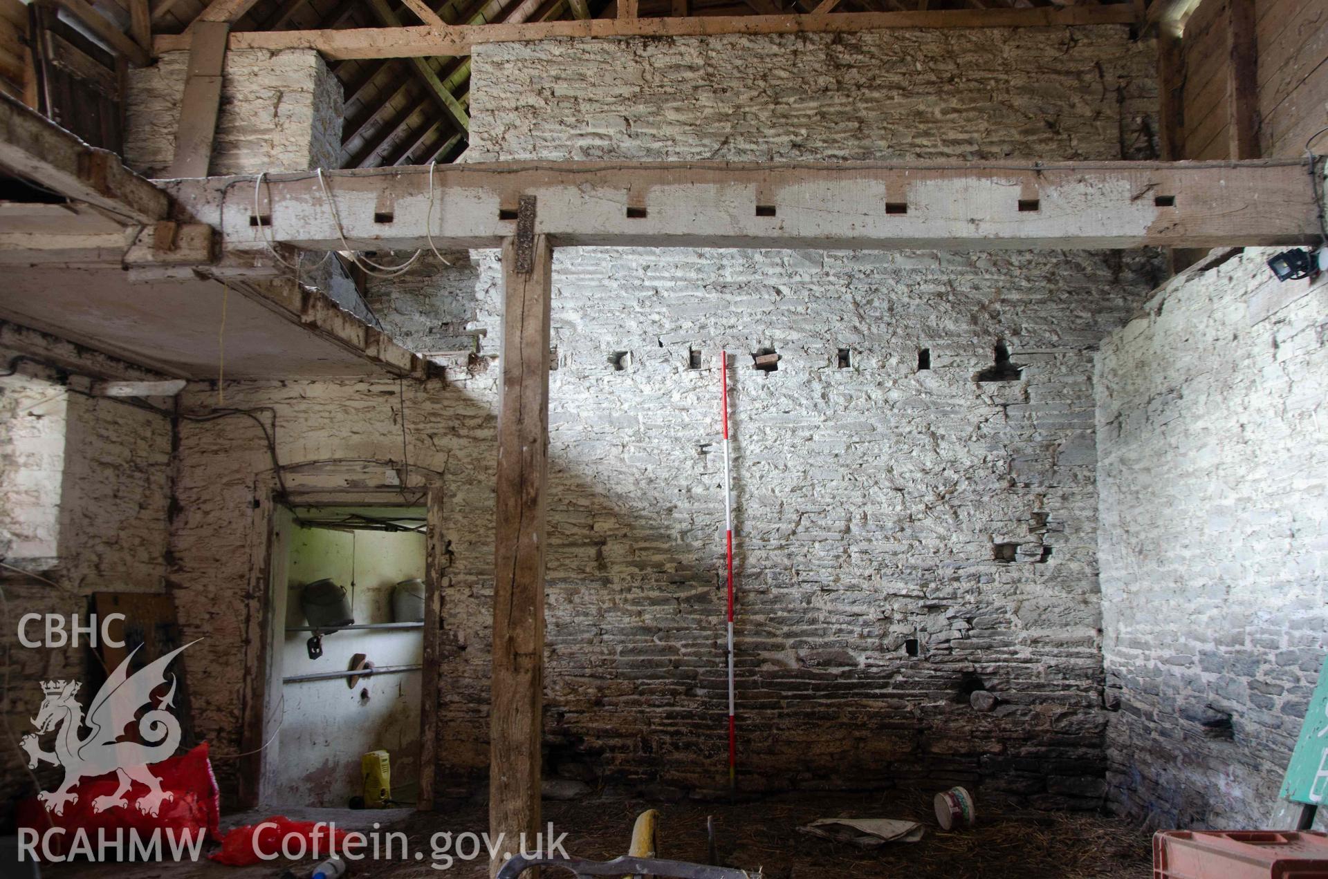 Photograph showing Internal wall separating cowhouse from the dairy, and which originally formed the gable end of the building. From a Photographic Survey of outbuildings at Upper House Farm Evenjobb, submitted as part of Listed Building consent. Photograph taken by Christopher Welch in April/June 2024.