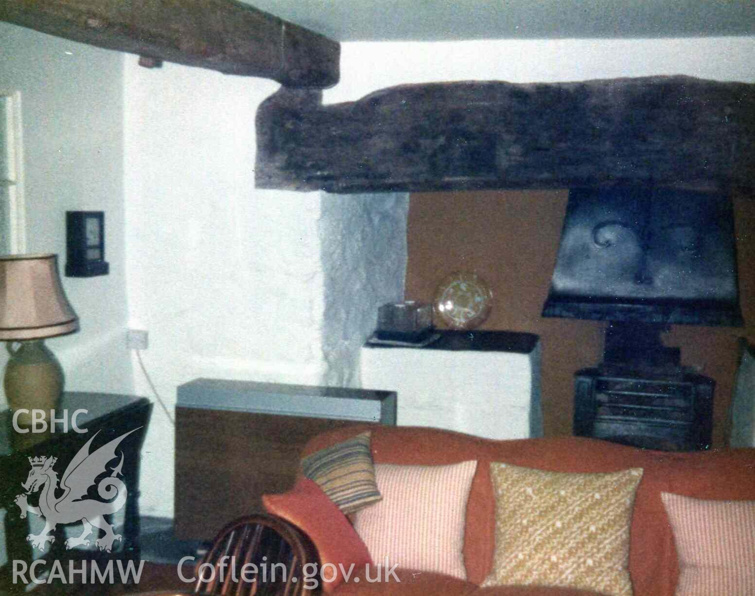Dining room in rebuilt southern end of Hafod Dwyryd. Fire canopy in inglenook made by local blacksmith. On the left, the wall conceals a second staircase. Electric storage heater installed. Photographed by Ronald and Joan Adams, probably in the early 1970s.