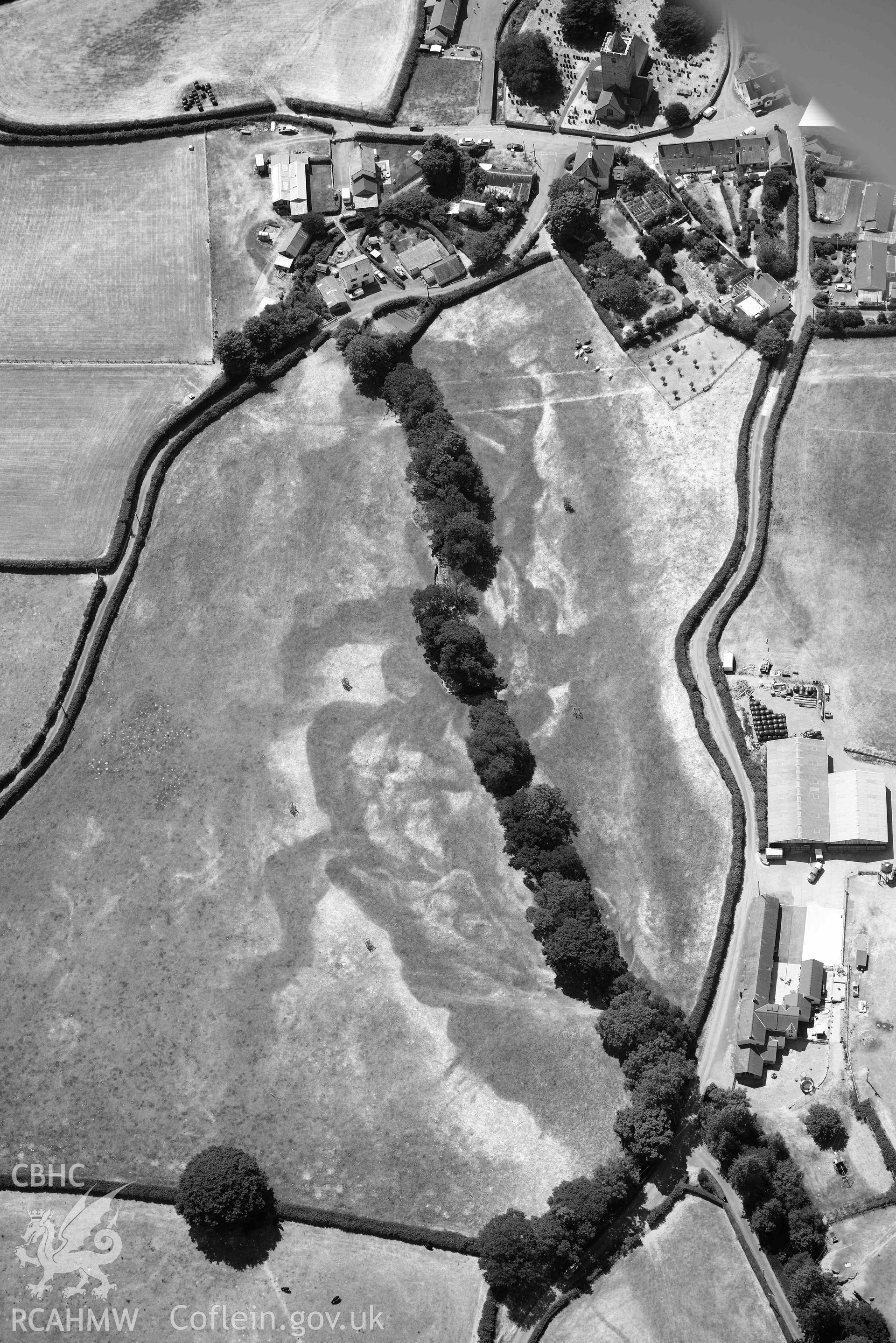 Cropmark in field immediately adjacent to Lisburne House, Llanfihangel y Creuddyn. Oblique black and white aerial photograph taken during the Royal Commission’s programme of archaeological aerial reconnaissance by Toby Driver on 10 July 2018.