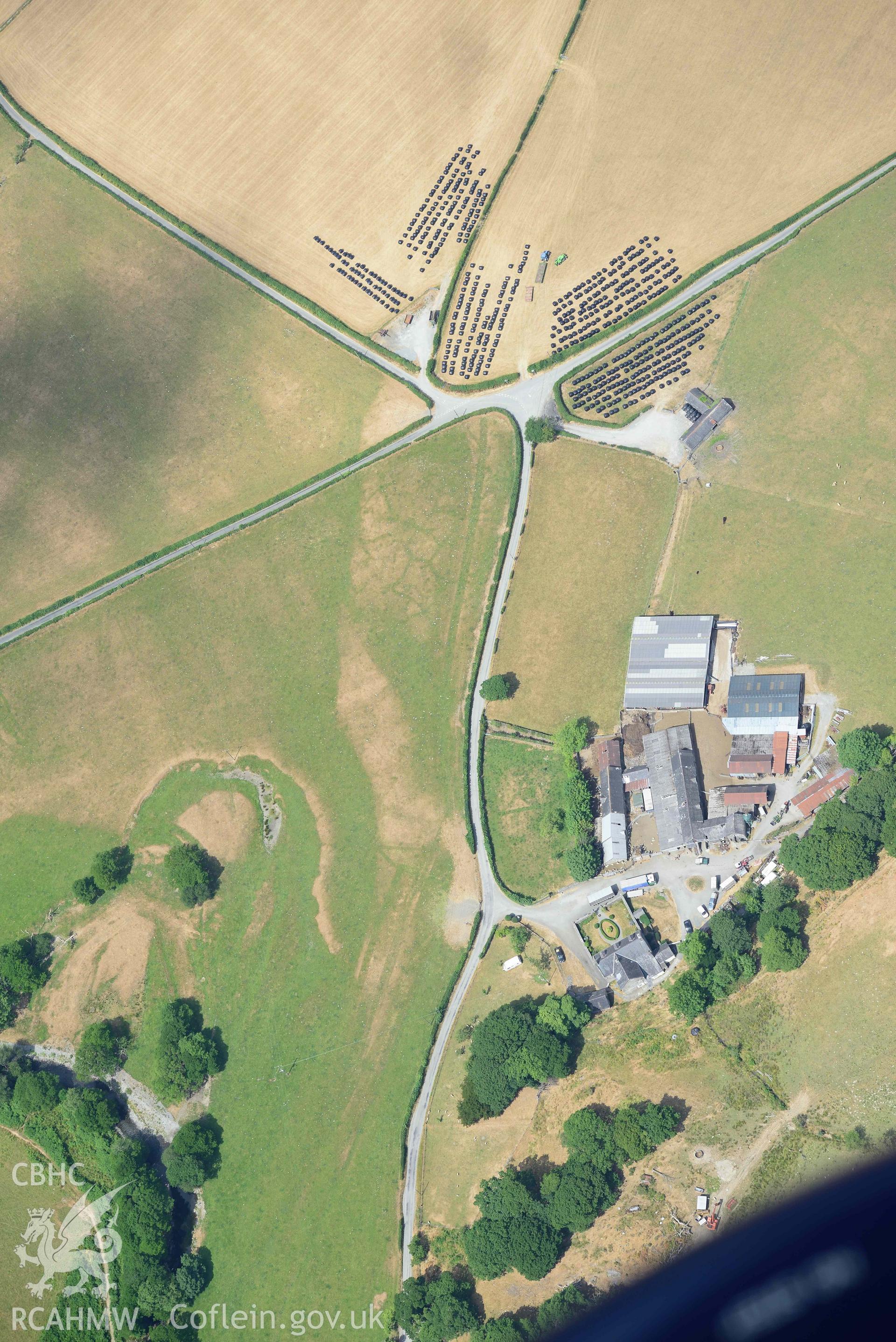Caer Berllan farm and ditch, with silage bales. Oblique aerial photograph taken during the Royal Commission’s programme of archaeological aerial reconnaissance by Toby Driver on 10 July 2018.