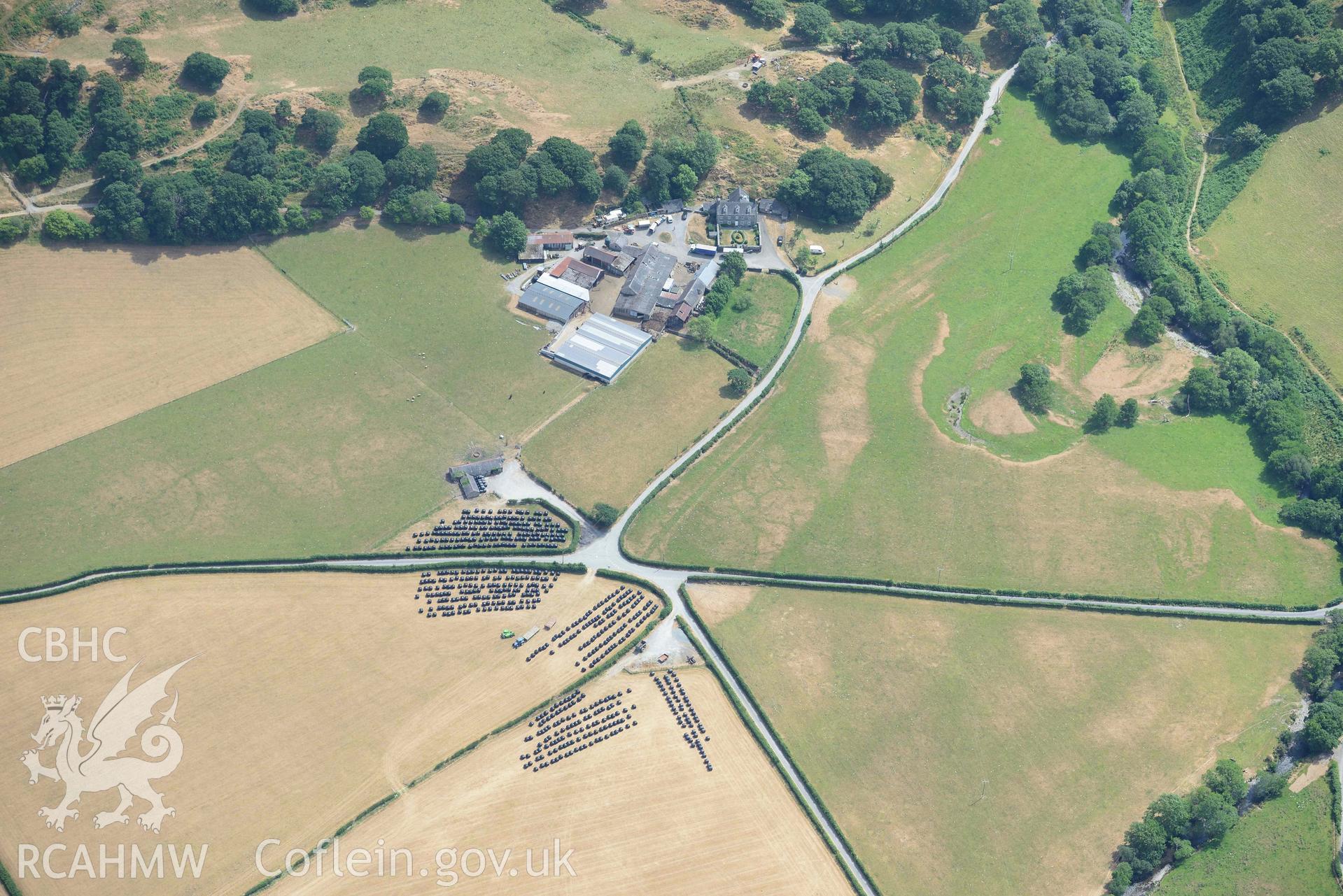 Caer Berllan farm and ditch, with silage bales. Oblique aerial photograph taken during the Royal Commission’s programme of archaeological aerial reconnaissance by Toby Driver on 10 July 2018.