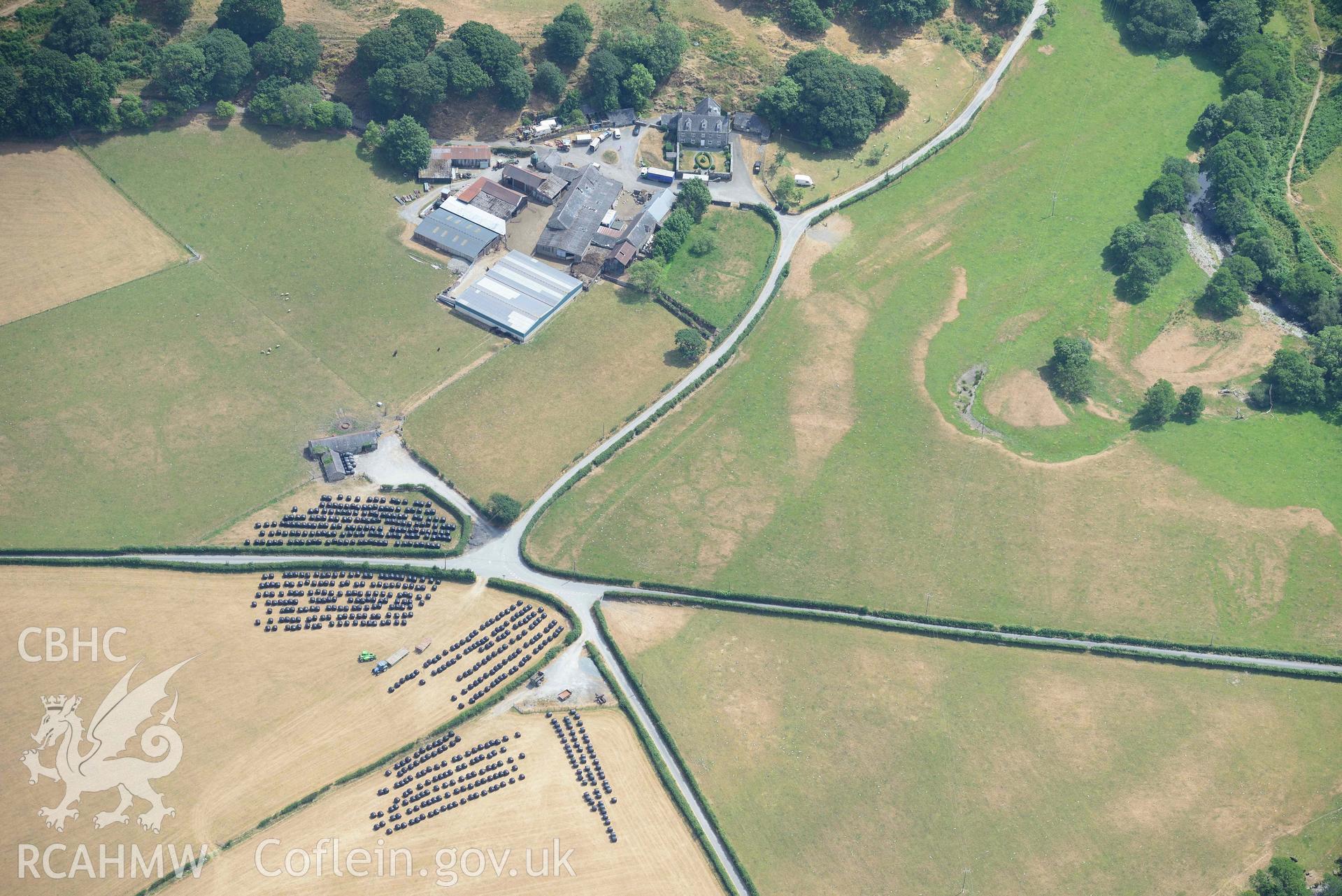 Caer Berllan farm and ditch, with silage bales. Oblique aerial photograph taken during the Royal Commission’s programme of archaeological aerial reconnaissance by Toby Driver on 10 July 2018.