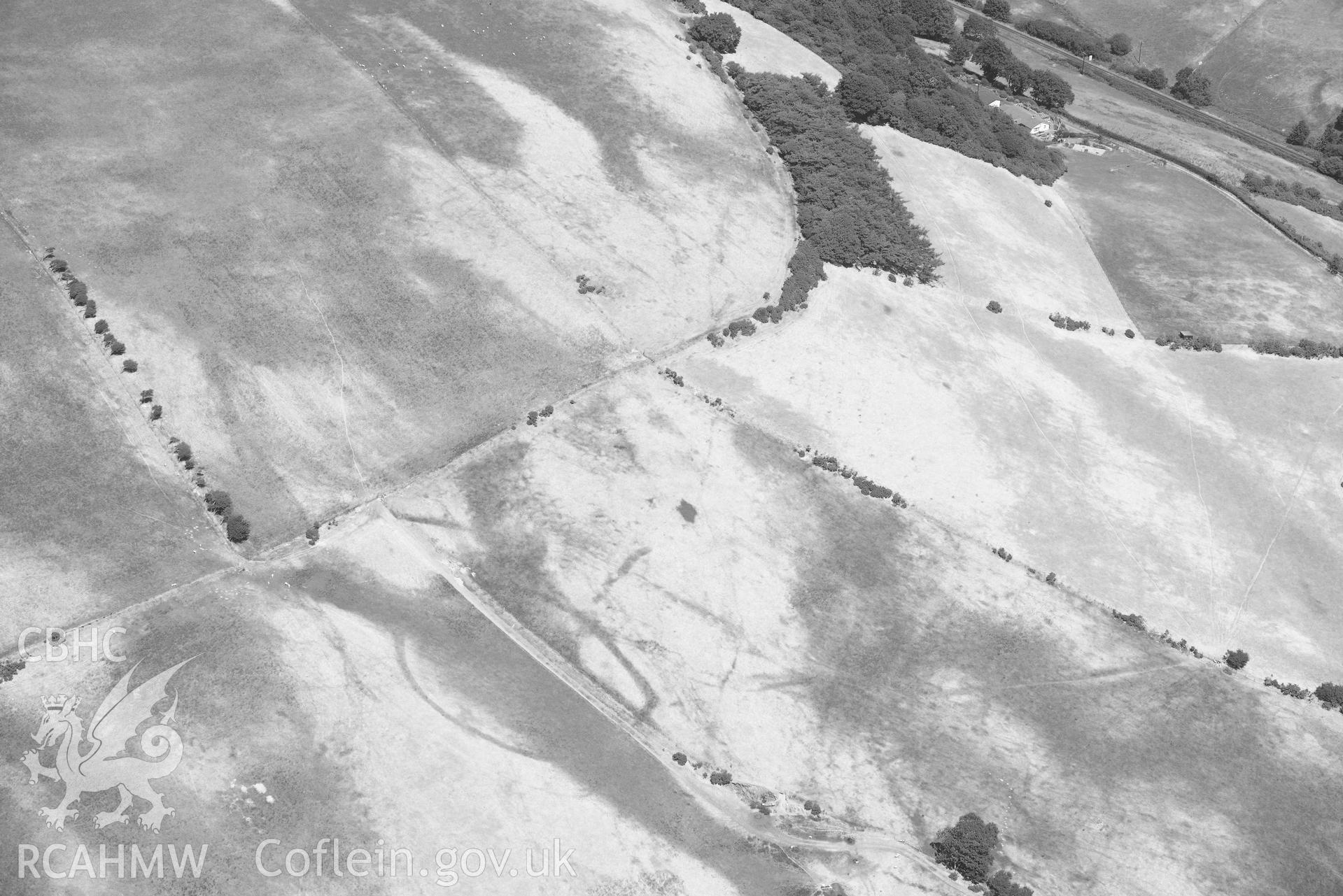 Ruel Uchaf enclosure. Oblique black and white aerial photograph taken during the Royal Commission’s programme of archaeological aerial reconnaissance by Toby Driver on 10 July 2018.
