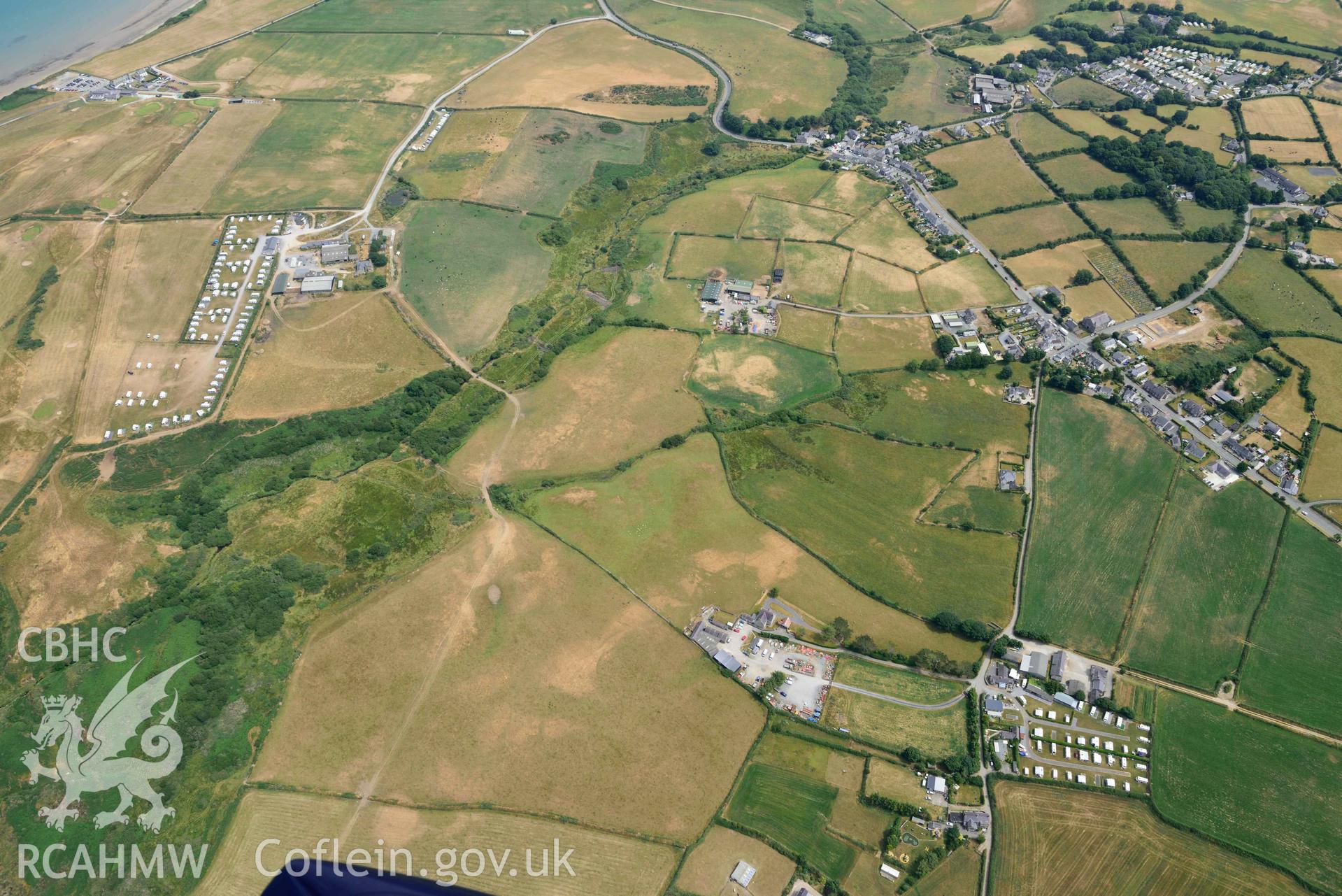 Pwll Parc cropmark enclosure and general landscape west of Morfa Nefyn. Oblique aerial photograph taken during the Royal Commission’s programme of archaeological aerial reconnaissance by Toby Driver on 10 July 2018.