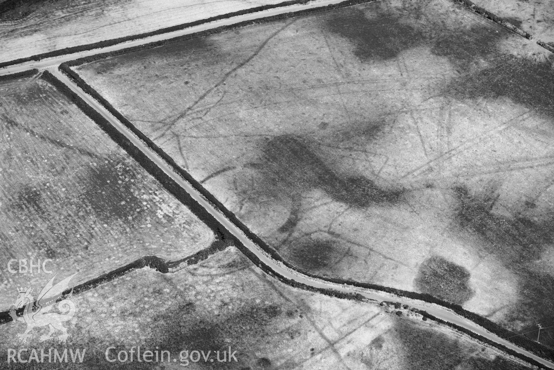 Detailed view of Baroch fawr cropmark enclosure. Oblique black and white aerial photograph taken during the Royal Commission’s programme of archaeological aerial reconnaissance by Toby Driver on 10 July 2018.