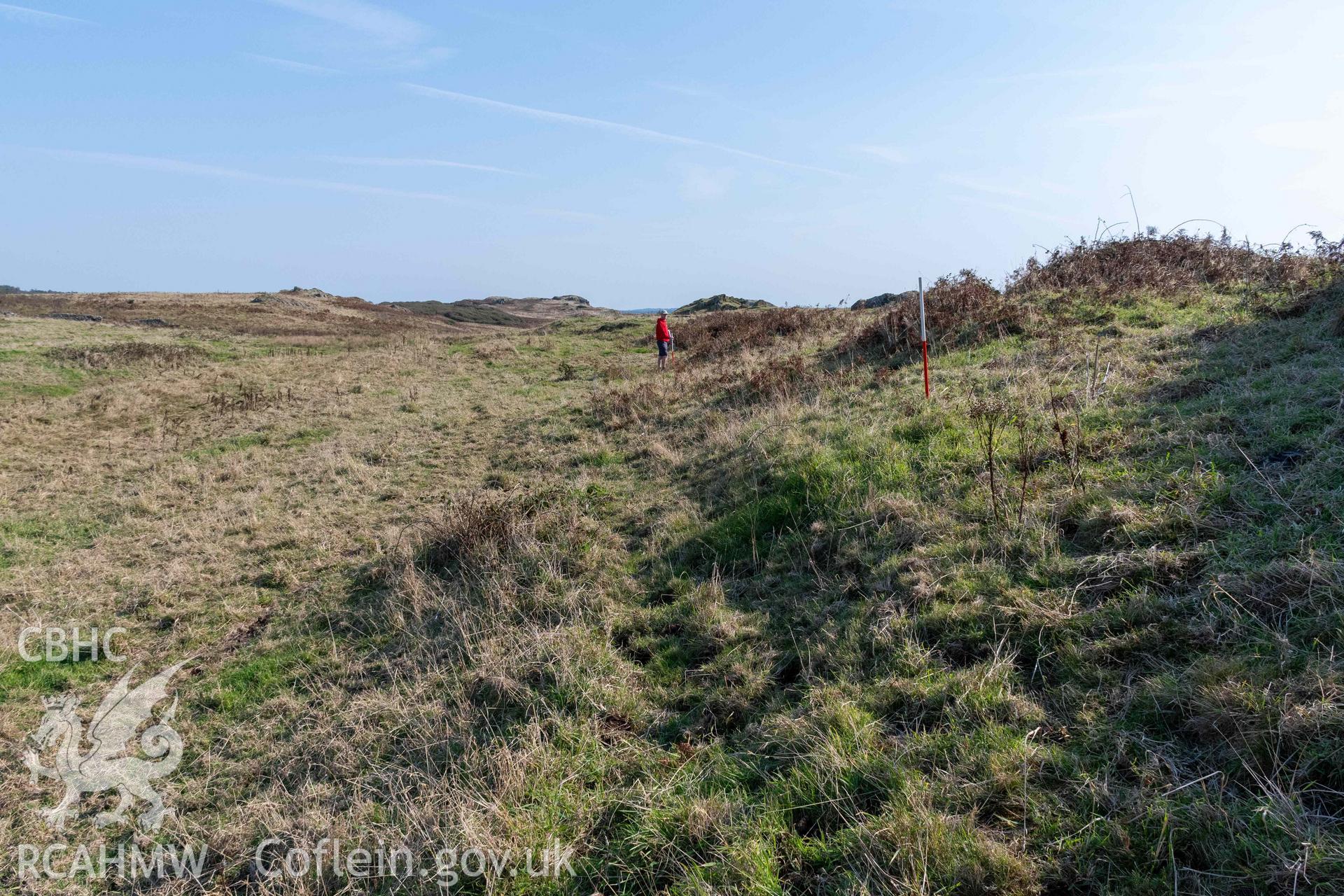 Twyn y Parc Coastal Promontory Fort. Looking northeast from base of inner rampart, with the outer bank and ditch running from Porth Fain visible to the left (with scale).