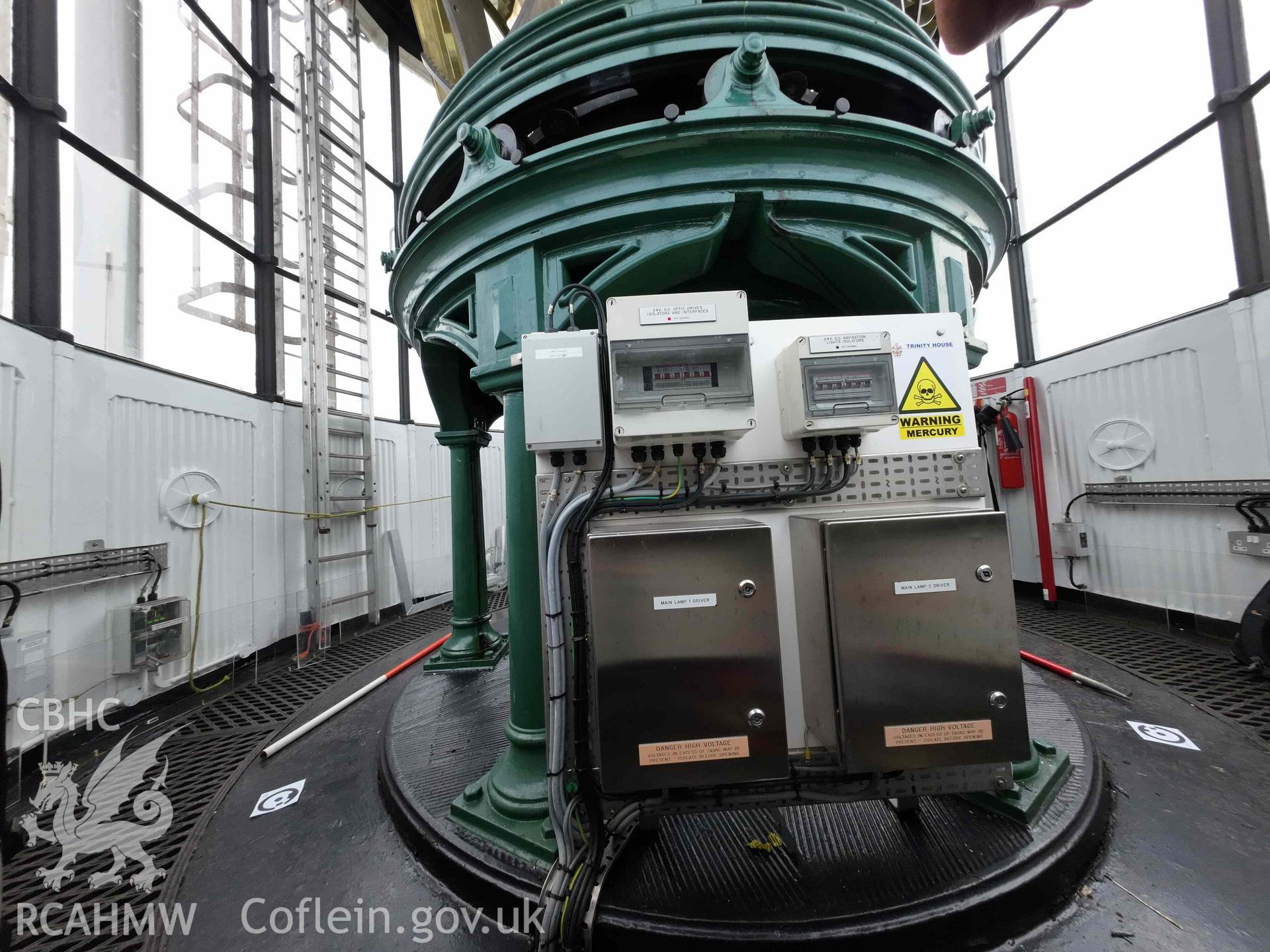 General wide-angle view of the lens pedestal within the Skerries Lighthouse lantern room on 16/07/2024, including the modern electrical circuit board.