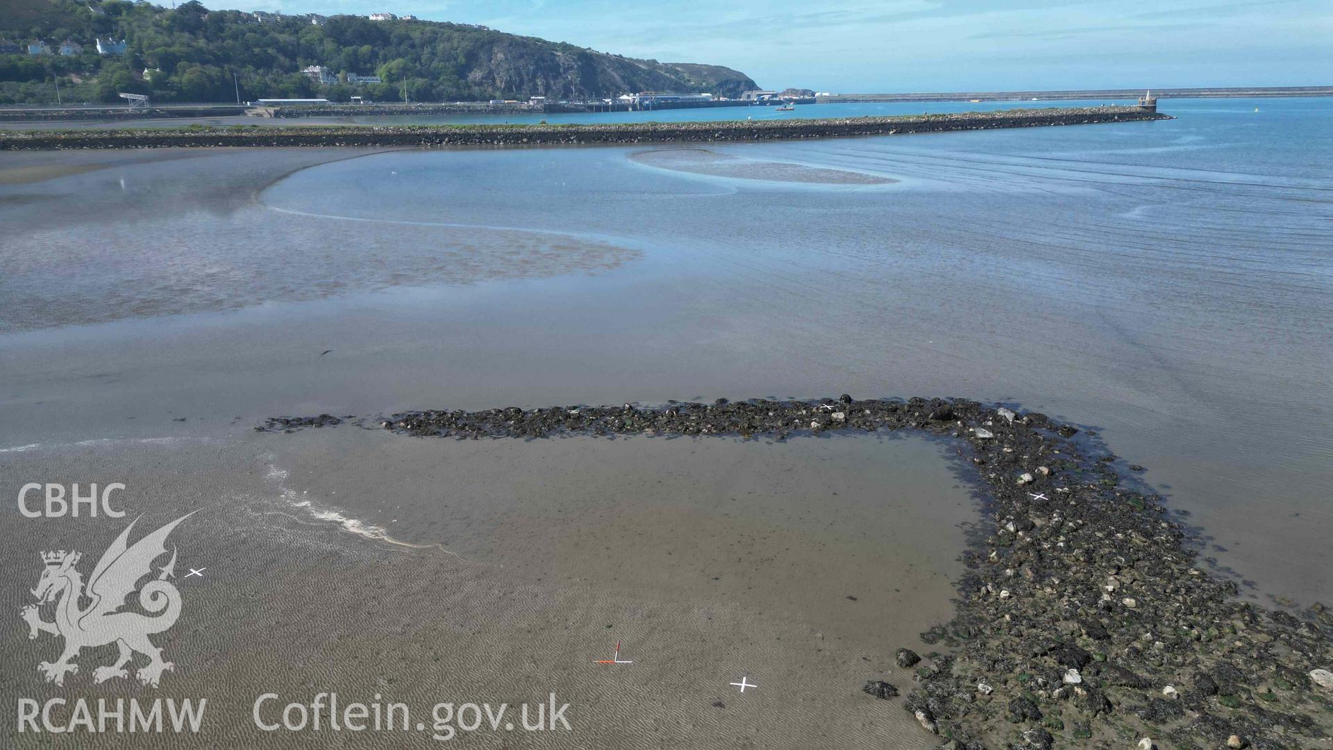 Oblique view, looking north, of Goodwick Fish Trap 2 at low tide on 09/05/2024. Fishguard port is visible in the background. Scales are 1m.