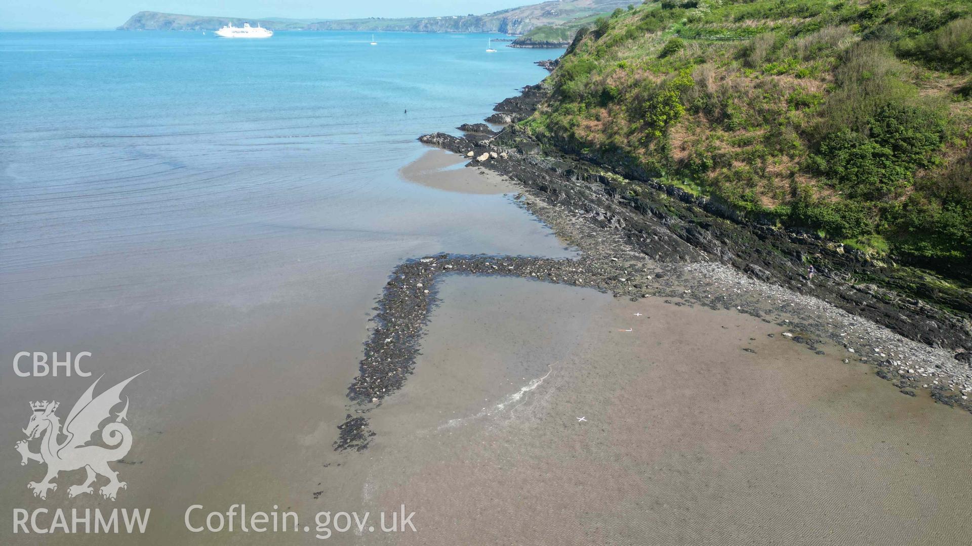 Oblique view, looking east, of Goodwick Fish Trap 2 at low tide on 09/05/2024. Fishguard Bay and Dinas Head are visible in the background. Scales are 1m.