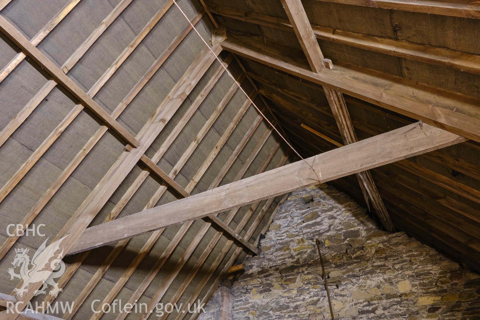 Photograph looking W to roof truss and full-height internal dividing wall to central section of building, from a Level 3 Historic Building Record for The Old Probate Registry, Llandaff, Cardiff. Prepared by Holland Heritage in 2024 as a condition of listed planning consent.