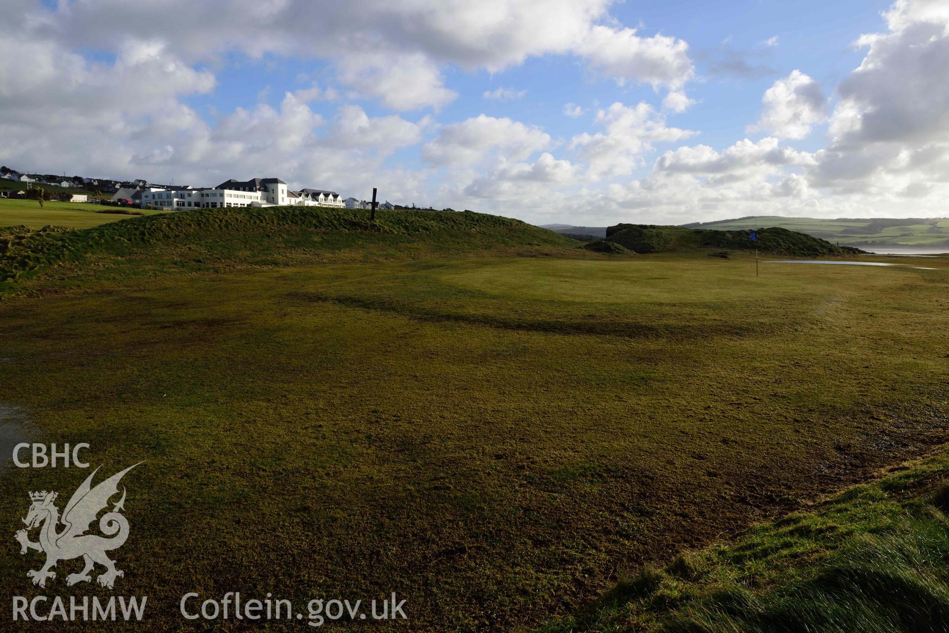 Looking southeast across the hillfort interior (now a golf course) to the hillfort entrance and defining bank.