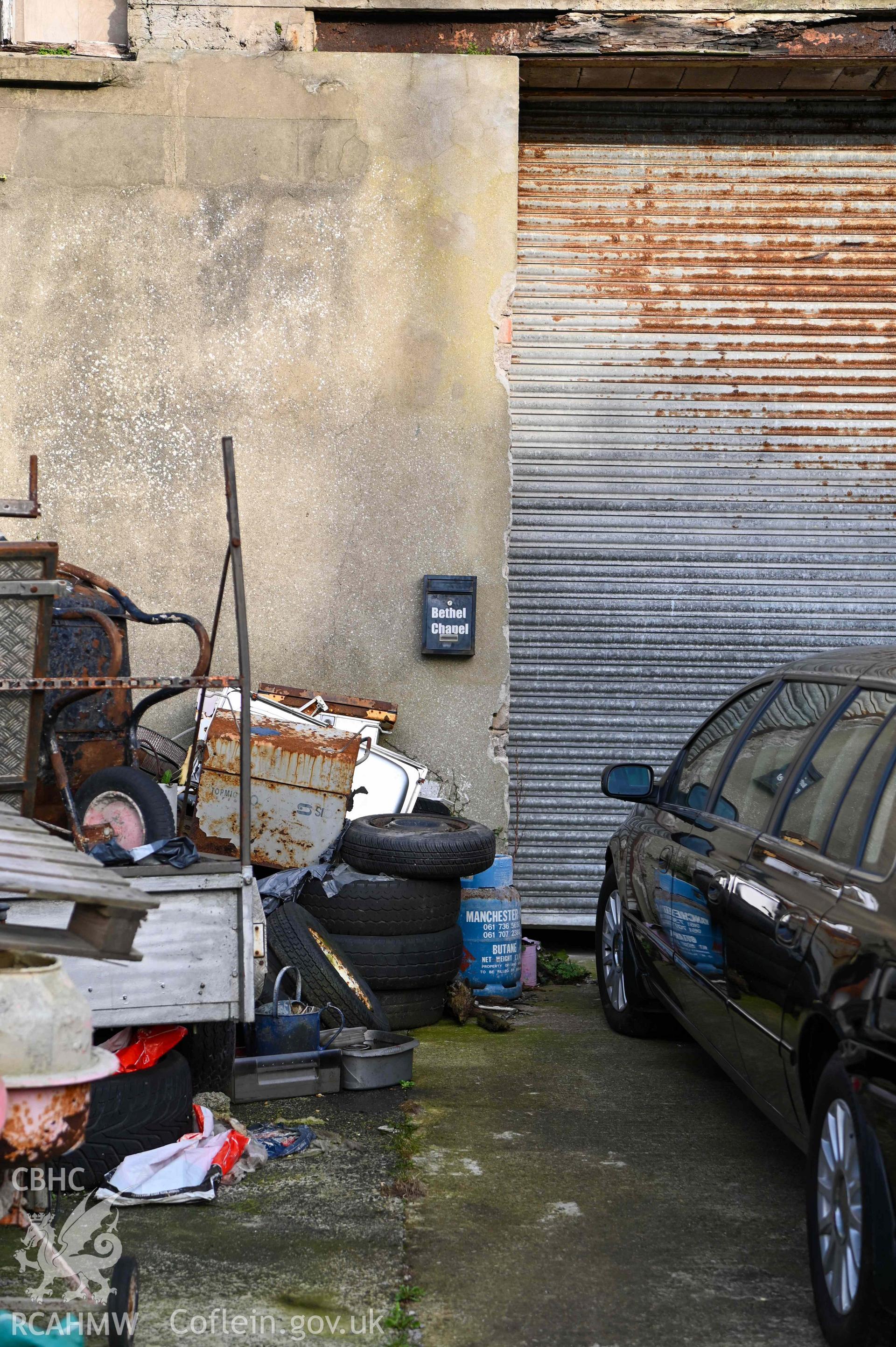 Welsh Methodist Church - Image of a church collection box, scrap metal and a car surround it, taken from South-East