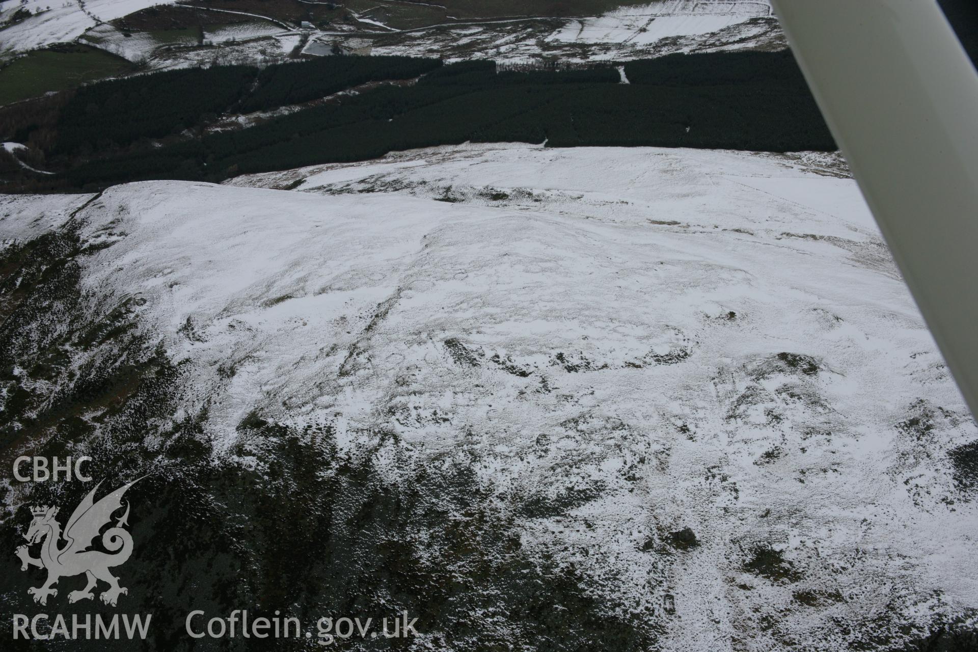 RCAHMW colour oblique aerial photograph of Craig Rhiwarth Hillfort under snow from the south. Taken on 06 March 2006 by Toby Driver.