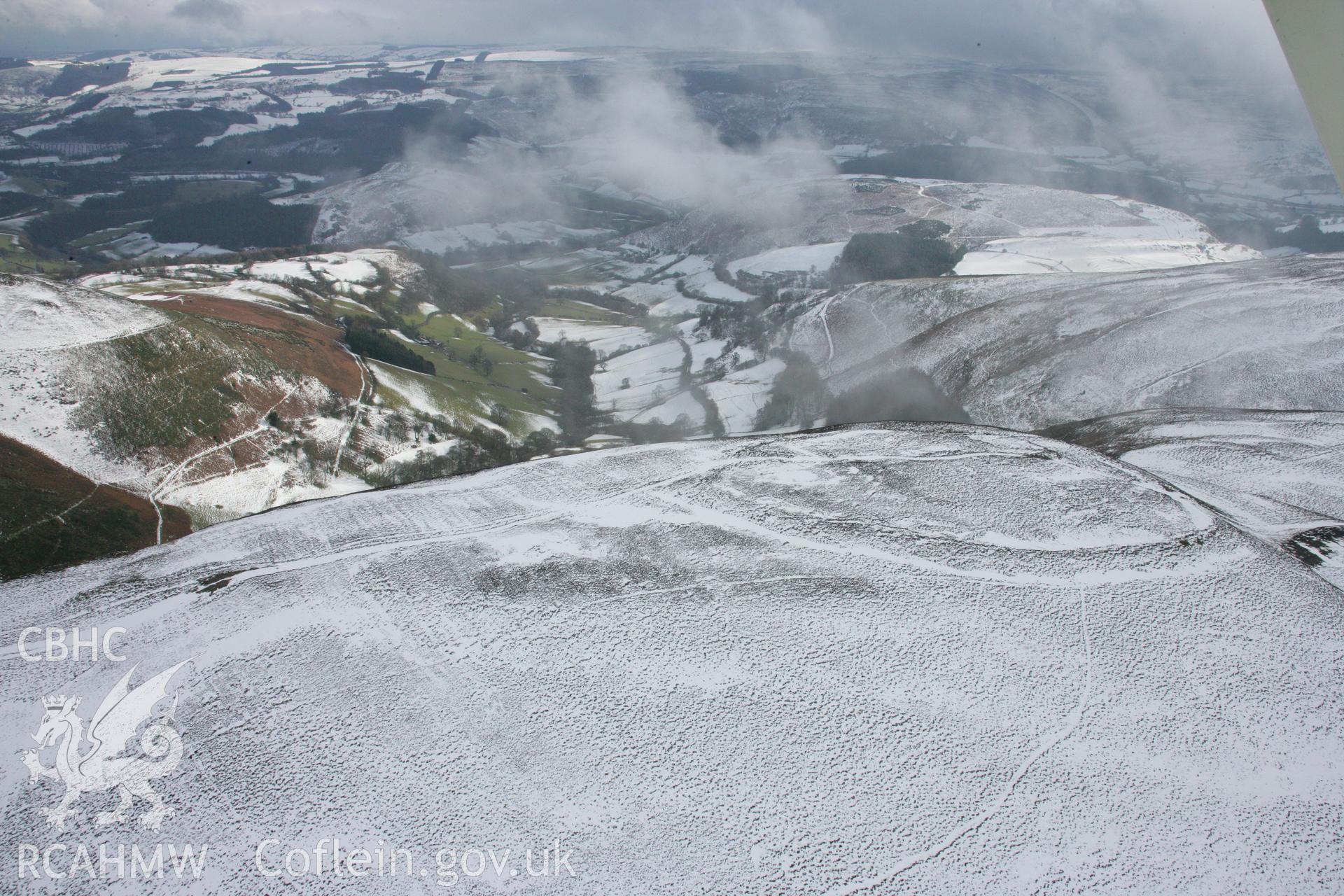 RCAHMW colour oblique aerial photograph of Moel-y-Gaer Hillfort, Llantysilio, in winter landscape viewed from the north-east. Taken on 06 March 2006 by Toby Driver.