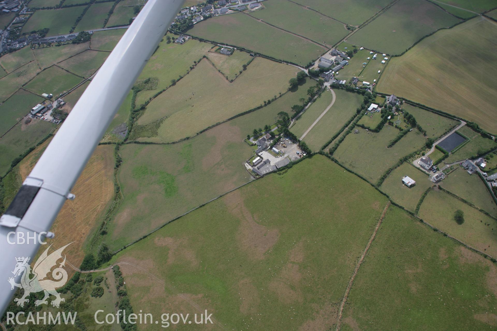 RCAHMW colour oblique aerial photograph of Pwll Parc Cropmark Enclosure. A wide view from the north-west. Taken on 03 August 2006 by Toby Driver.