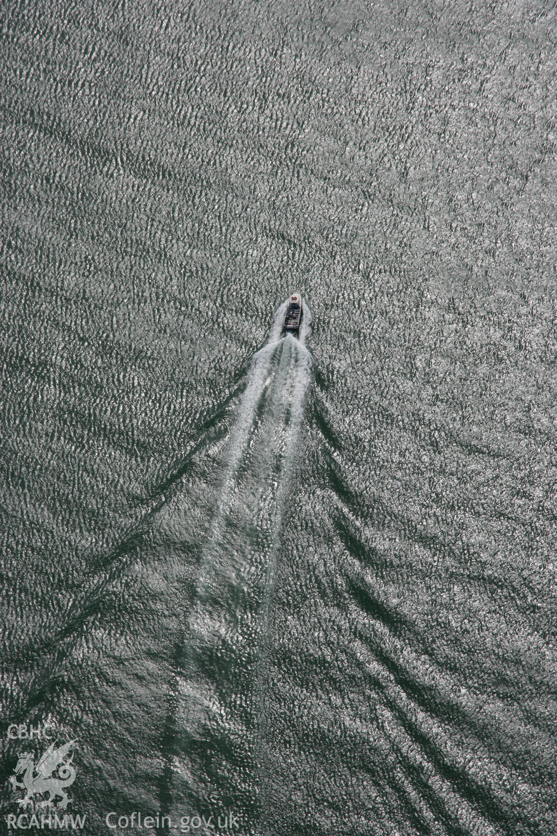RCAHMW colour oblique aerial photograph of pleasure boat near Penmon Priory on Puffin Island (or Priestholm). Taken on 14 August 2006 by Toby Driver