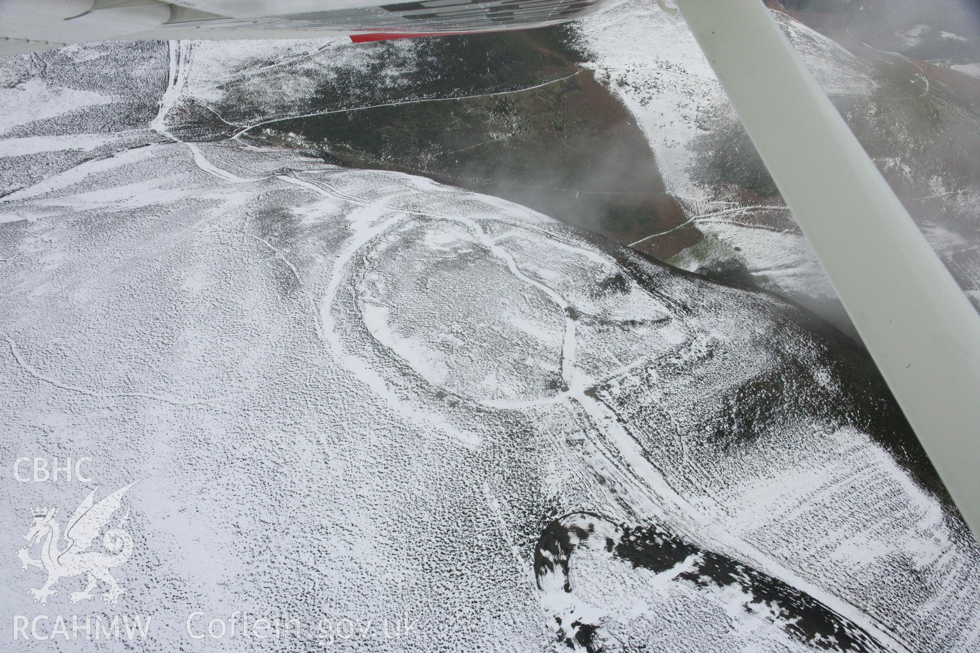 RCAHMW colour oblique aerial photograph of Moel-y-Gaer Hillfort, Llantysilio, in winter landscape viewed from the west. Taken on 06 March 2006 by Toby Driver.