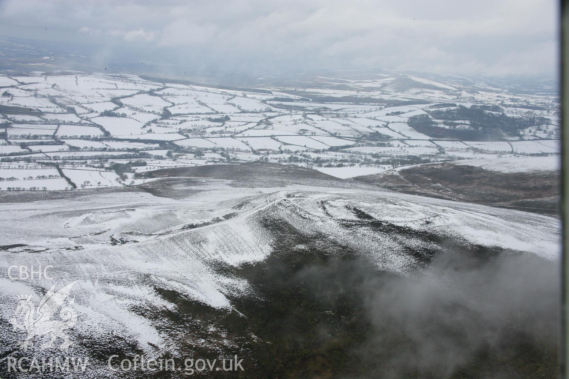 RCAHMW colour oblique aerial photograph of Moel-y-Gaer Hillfort, Llantysilio in winter landscape from the south-west. Taken on 06 March 2006 by Toby Driver.