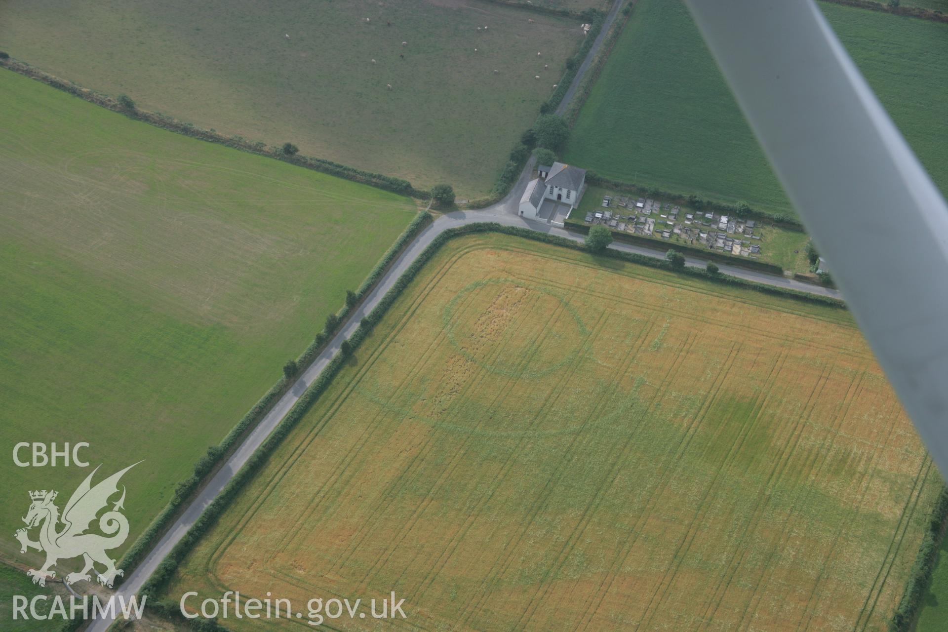 RCAHMW colour oblique aerial photograph of a cropmark enclosure east of Treferedd Uchaf. Taken on 21 July 2006 by Toby Driver.
