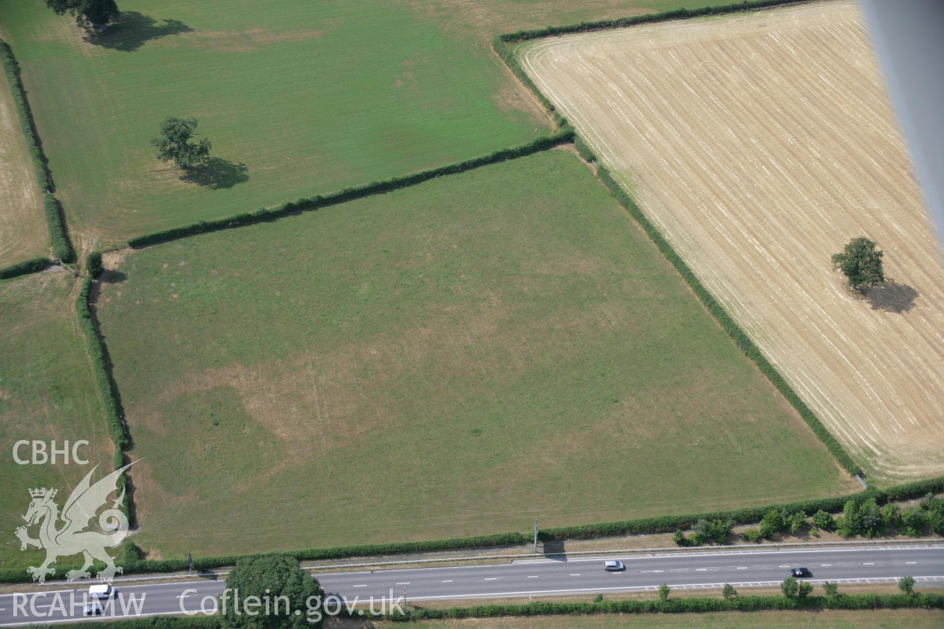 RCAHMW colour oblique aerial photograph of parchmarks approximately 200 metres to the north west of Llwyn-wron Cursus. Taken on 25 July 2006 by Toby Driver