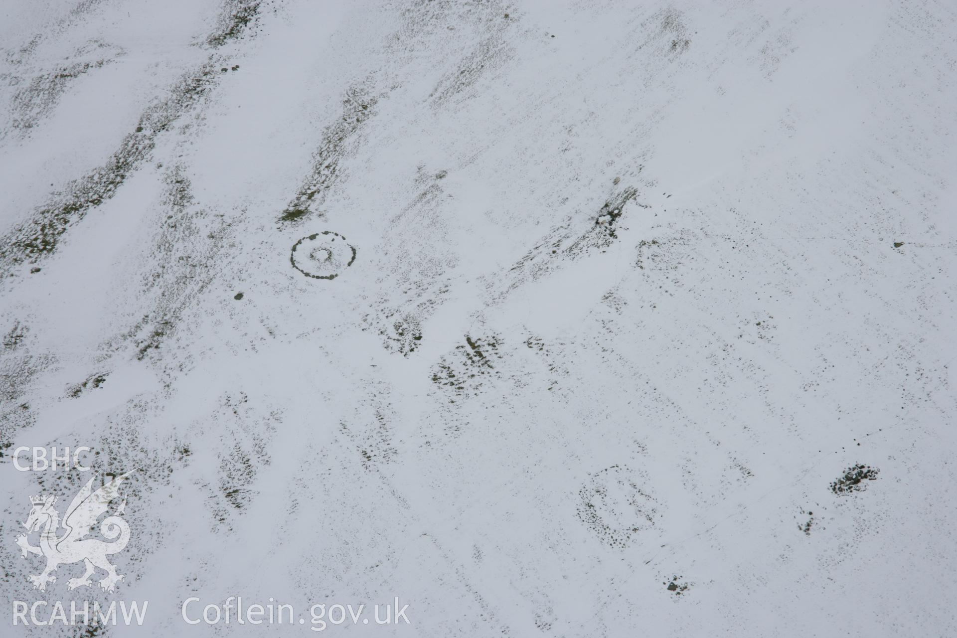 RCAHMW colour oblique aerial photograph of Moel Ty-Uchaf Kerb Circle, viewed under snow. Taken on 06 March 2006 by Toby Driver